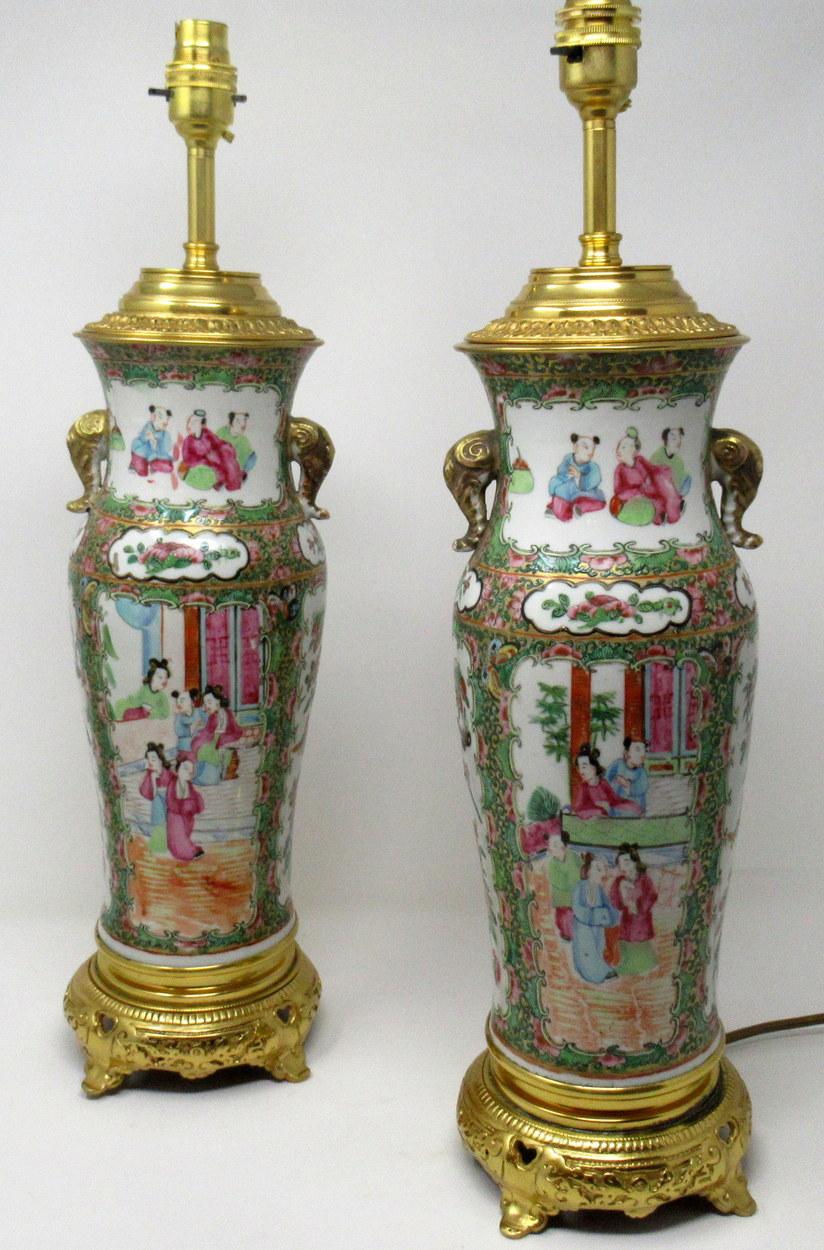 An exceptionally fine pair of Cantonese hand decorated porcelain oil lamps with ornate ormolu bases now converted to electric table lamps, of good size proportions, mid-19th century. 

The main outer bodies of bulbous form with hand-painted panels
