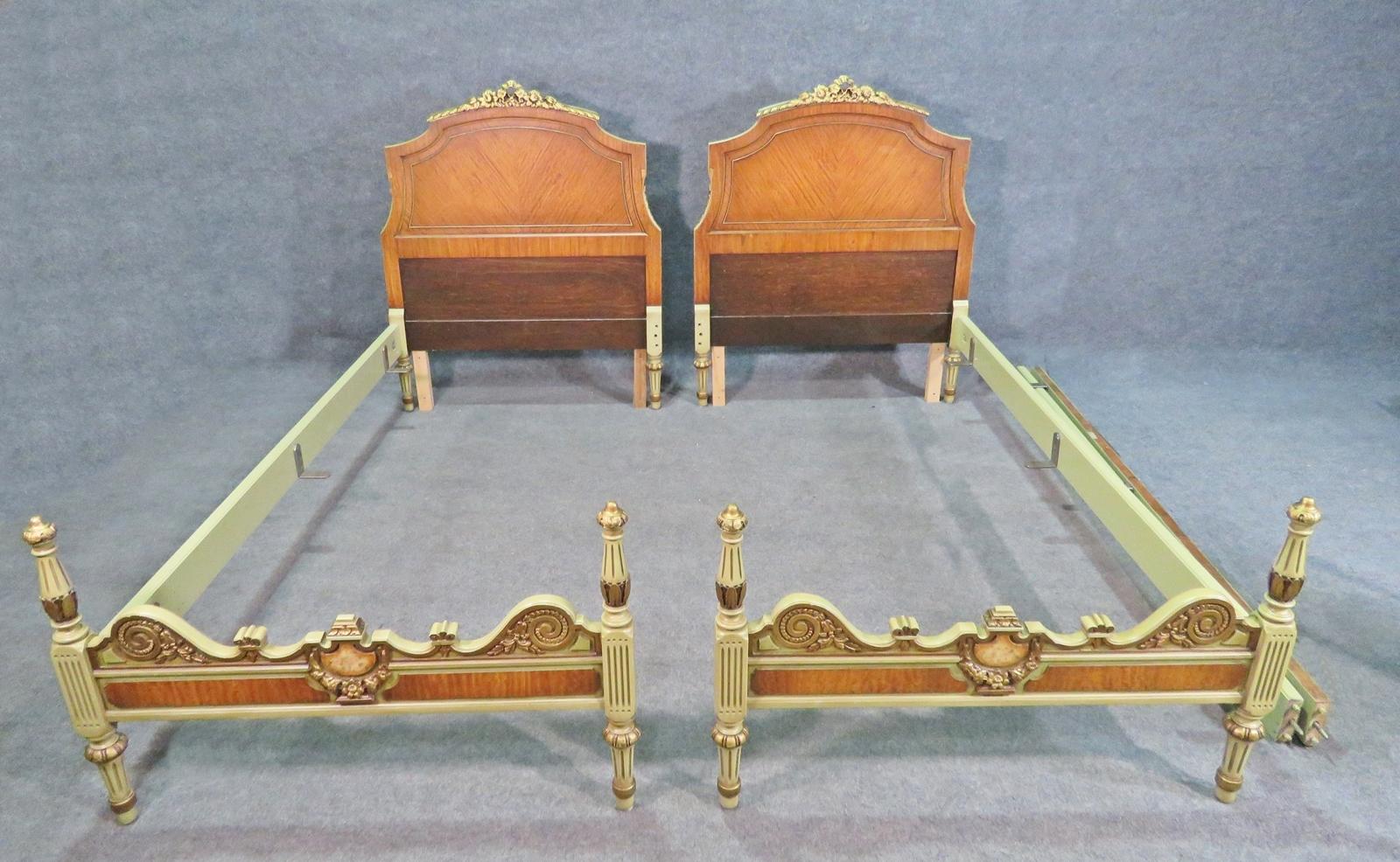 This is a beautiful pair of beds. They may be slightly narrower than a standard twin so please measure if you want to use the original rails. Walnut veneer. Painted accents. Carved top. With rails. 46 1/2