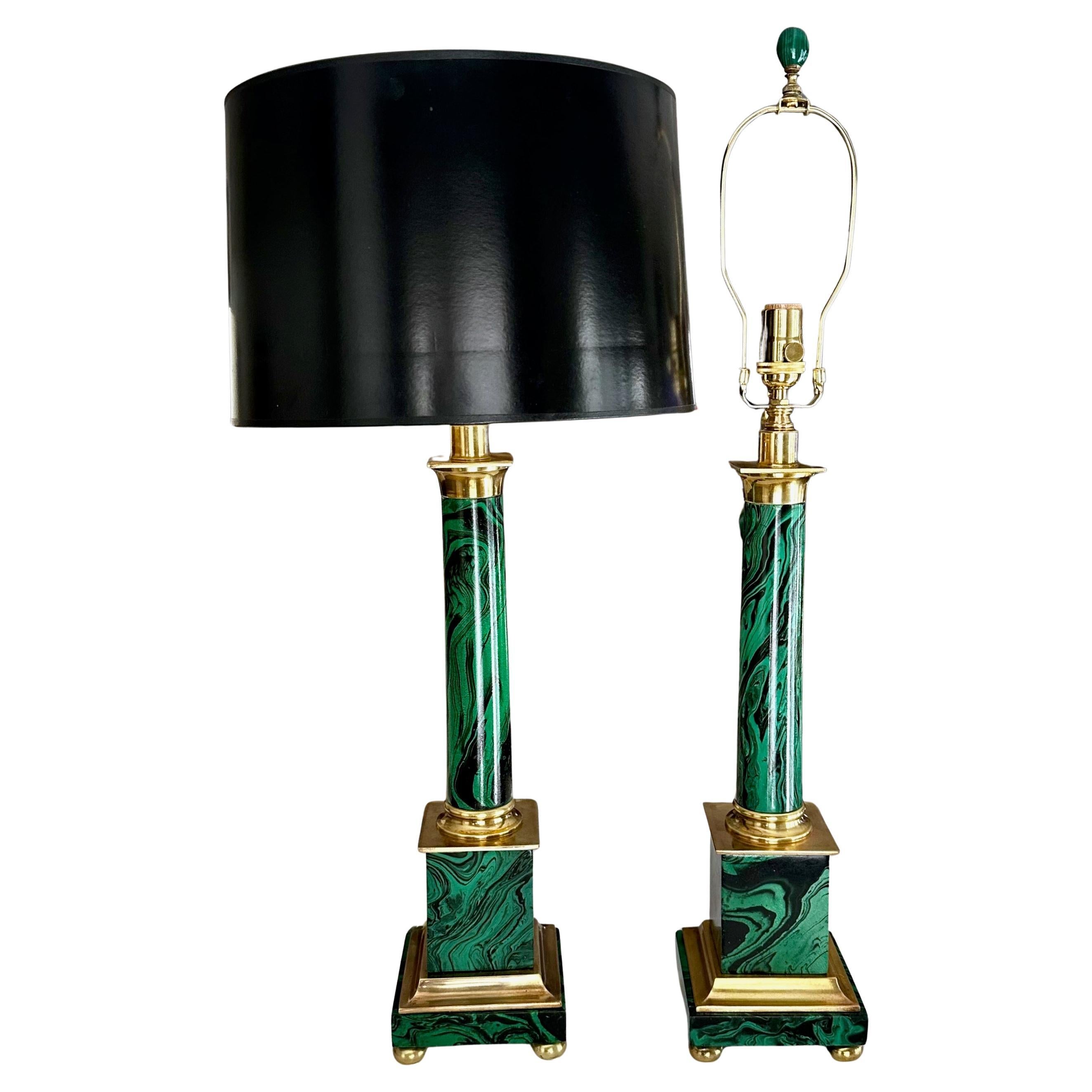 Pareja de elegantes lámparas de sobremesa de estilo neoclásico en forma de columna de metal de malaquita pintado a mano de los años 50. Las columnas de malaquita de imitación están decoradas con herrajes y bases de latón pesado bien trabajados.
