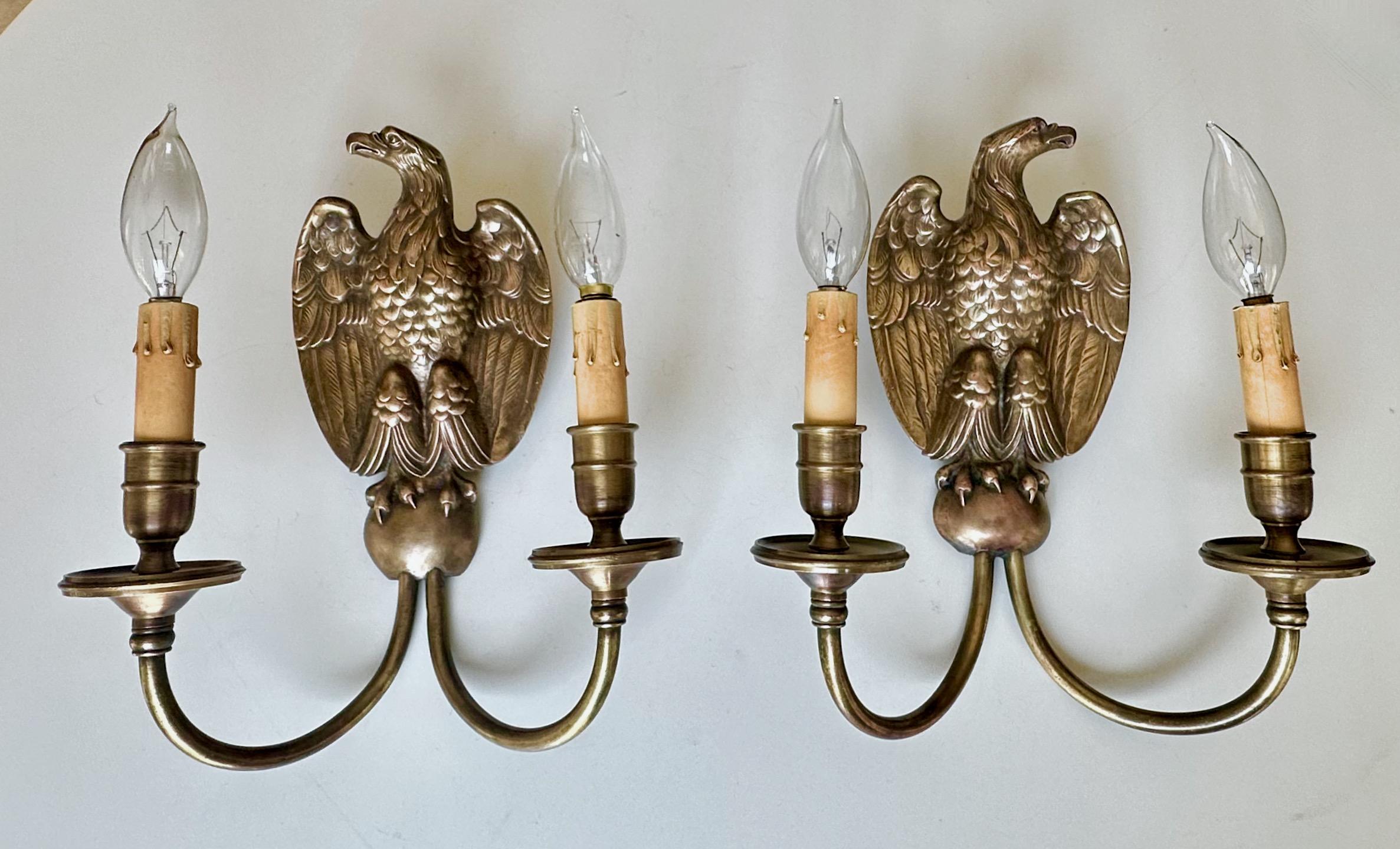 Paire d'appliques murales en bronze à motif d'aigle de style fédéral américain, fabriquées et estampillées par Sterling Bronze Company of New York. Chaque lampe utilise 2 ampoules de taille candélabre, nouvellement câblées. 