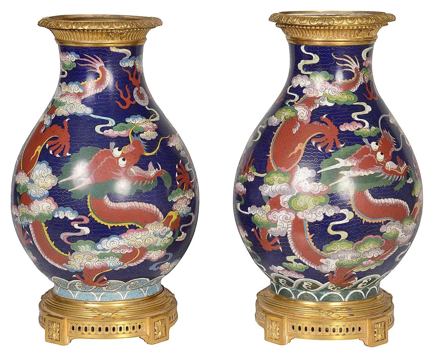 A fine quality pair of 19th century Chinese Cloisonne enamel vases, each with wonderful myithical Dragon flying among clouds. mounted with French gilded ormolu rims and plinths. 

Batch 70 61317. UYZZN.