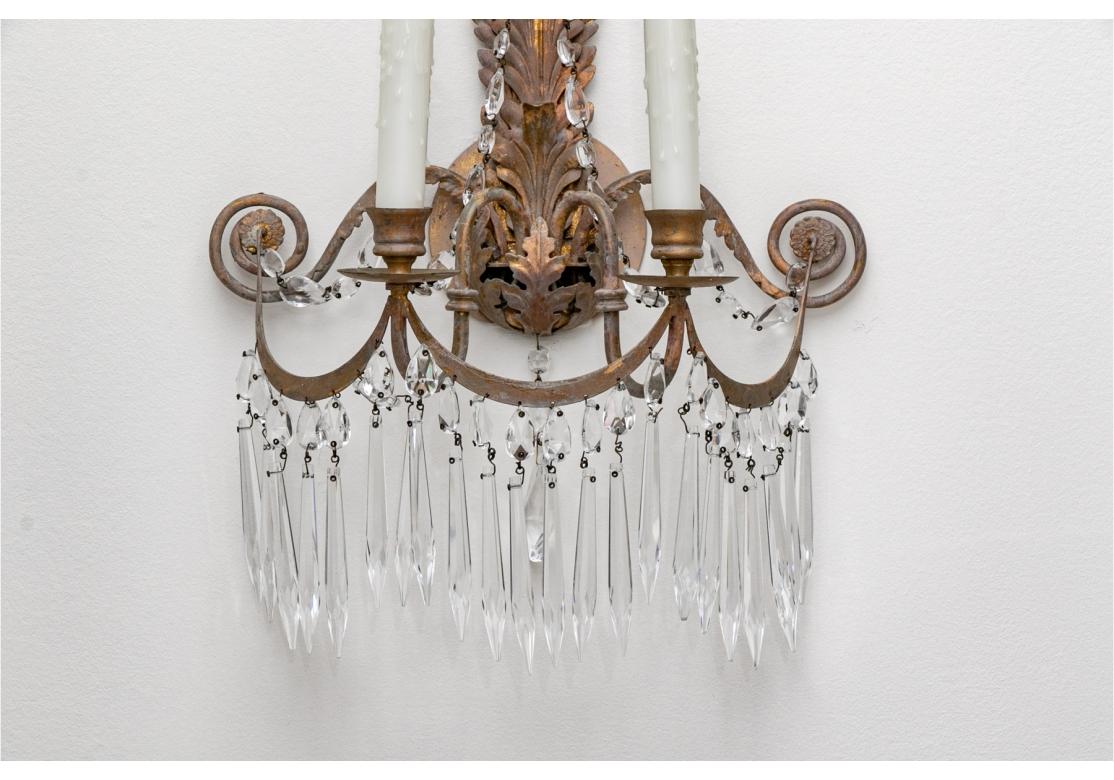 Apliques altos de latón con acabado verdigris de imitación y estandartes de hojas de acanto. Luces gemelas en forma de 