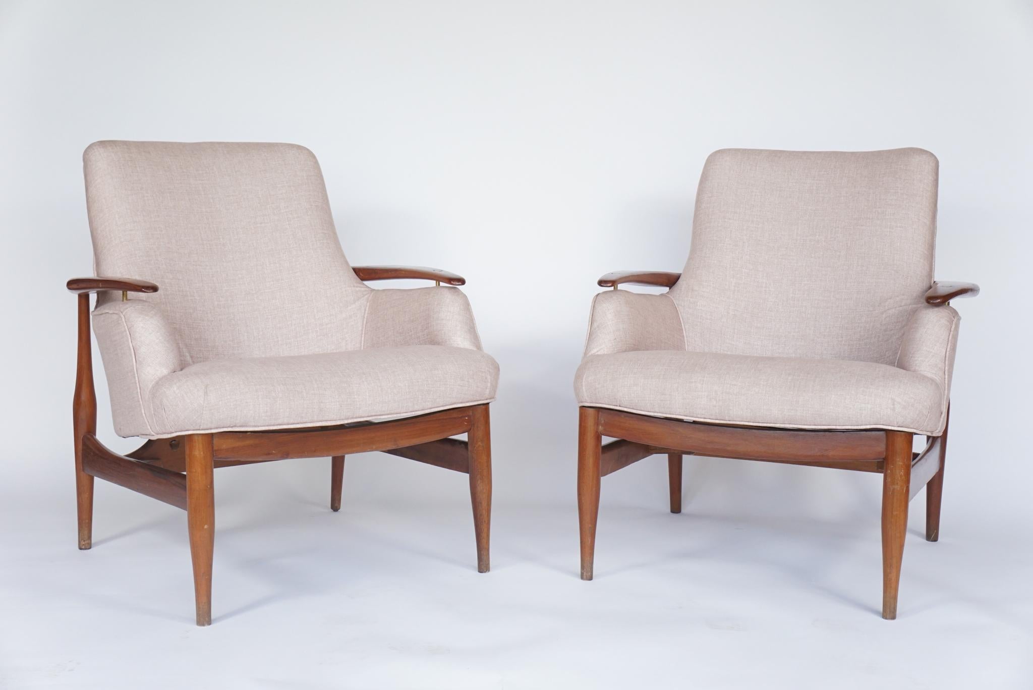 Pair of armchairs in the manner of Finn Juhl. Based on his model NV 53 chair, this Danish chair has floating armrests, with brass fittings sublime, Airy design with new upholstery.