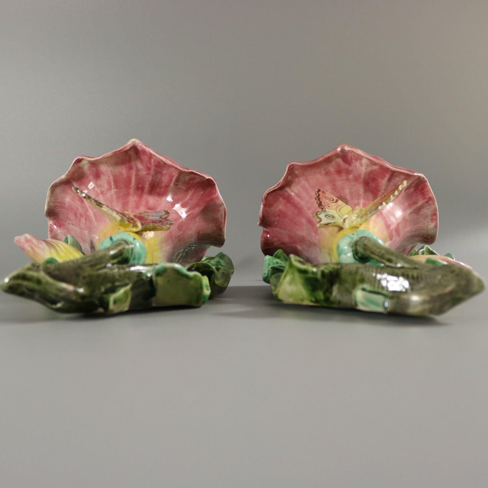Pair of Fives-Lille French Majolica wall pockets which feature a large flower on a bed of leaves. A butterfly sits on the flower. Colouration: pink, green, yellow, are predominant. The piece bears maker's marks for the Fives-Lille pottery. Bears a