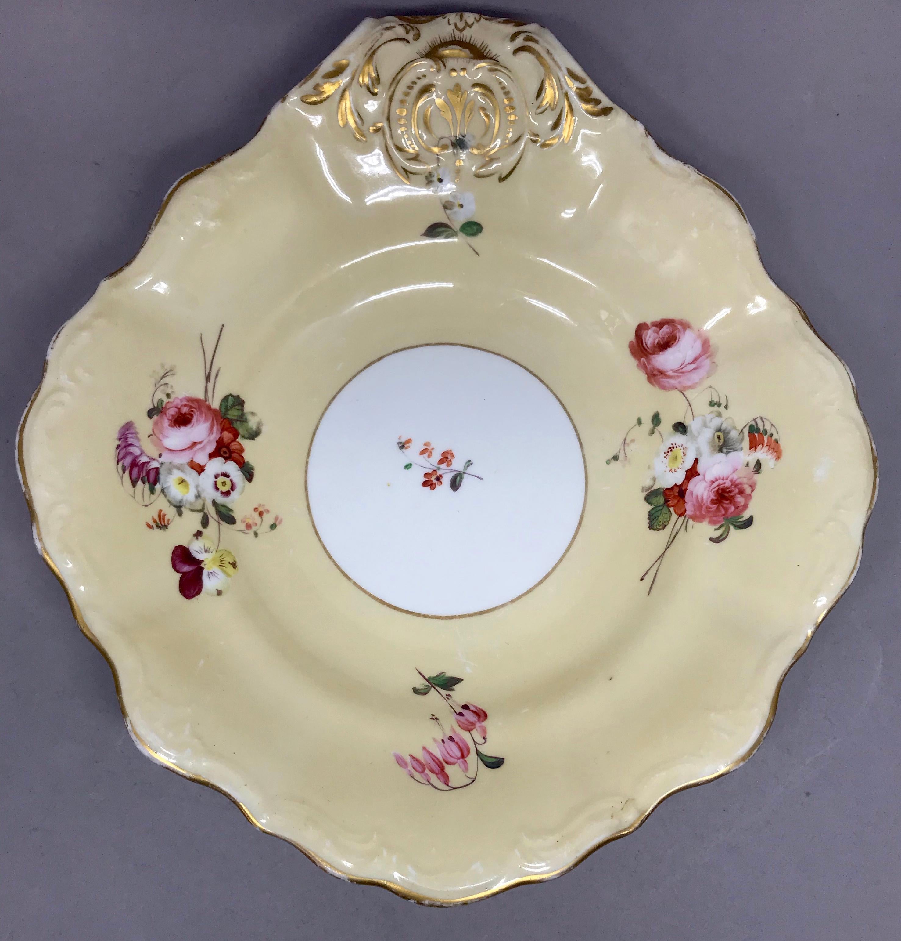 Pair of floral and gilt painted sweetmeat dishes. Pair of shell form sweetmeat dishes with gilding to handle and overall cornsilk field with hand painted rose floral sprays centering on white gilt rim medallion and further floral. Underglaze marking