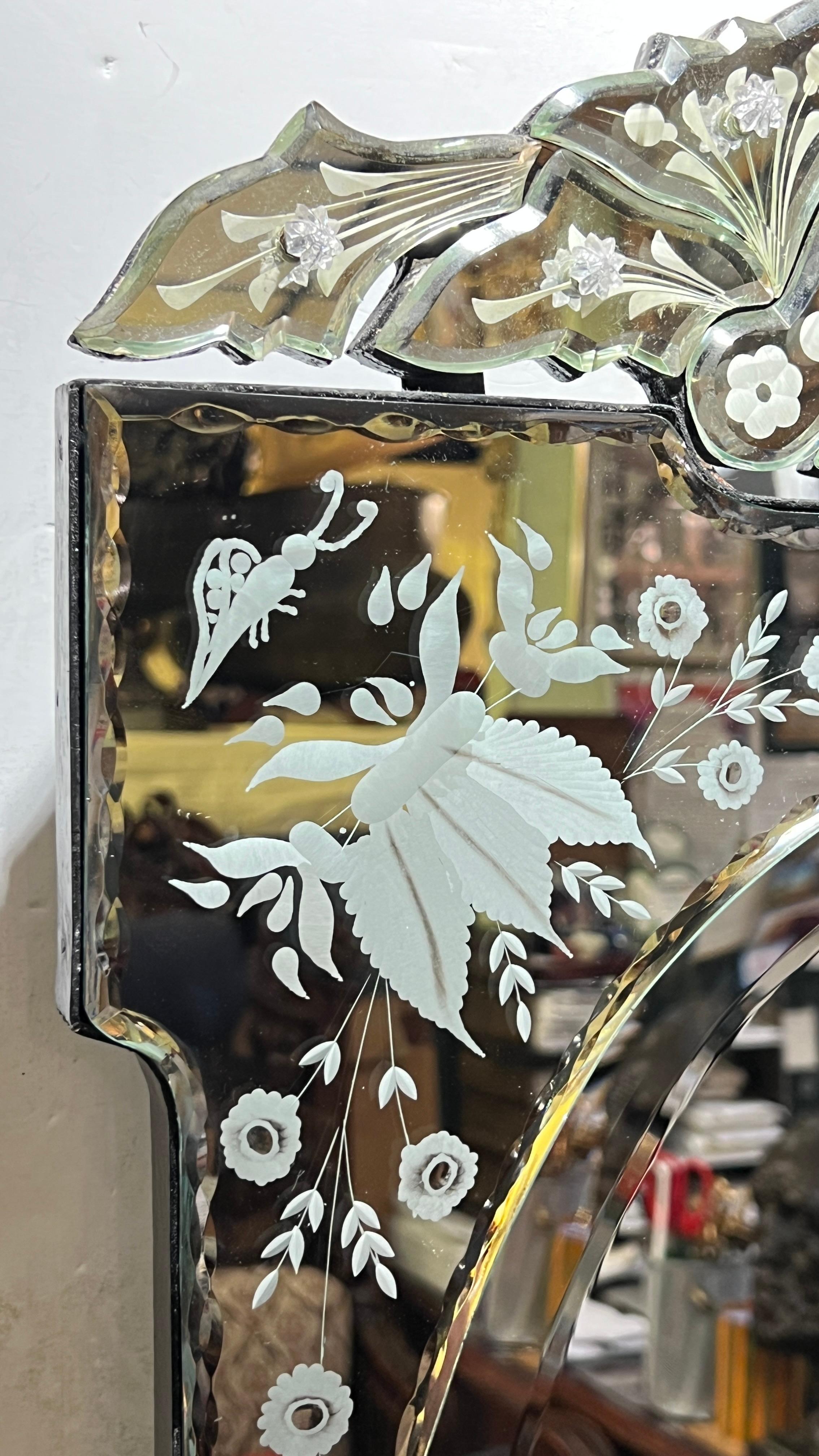 Pair of vintage Venetian wall mirrors engraved with floral designs with ebonized wooden frames, each 31 by 19 1/4 by 1 inch, and in very good condition.