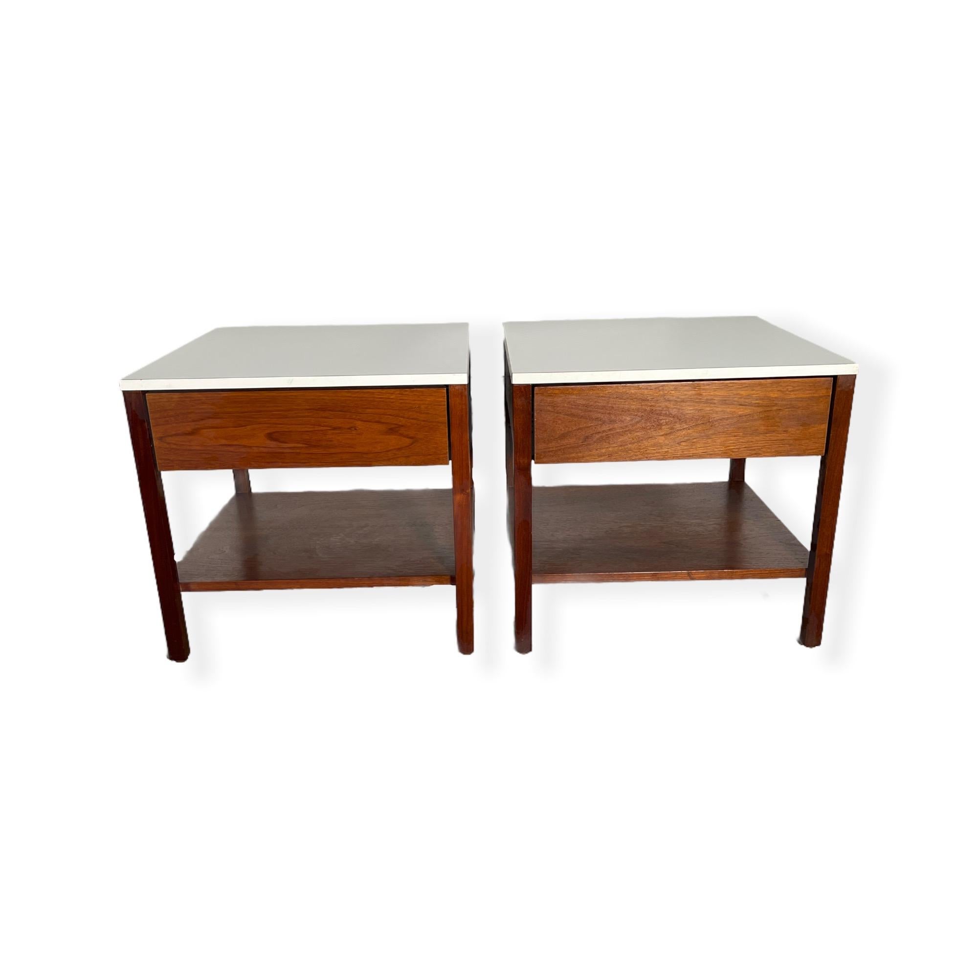 Pair of Mid-Century Modern walnut nightstands by Florence Knoll with White top. This nightstands features beautiful simple modern lines, stunning walnut wood grains, and one drawer. The nightstands are in good vintage condition. 

Measures: W