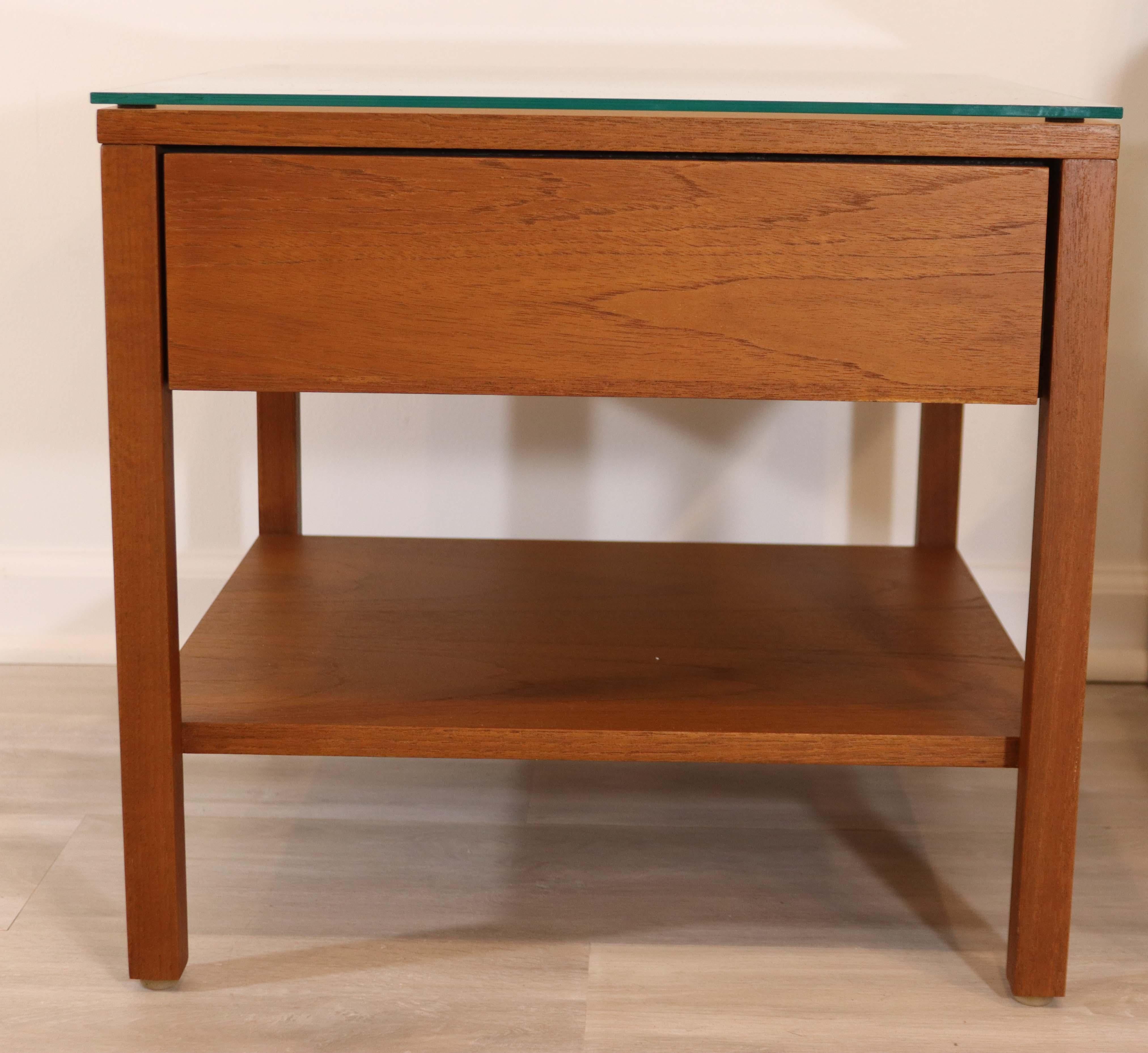 This early pair of walnut nightstands or side tables by Florence Knoll, circa 1950's are in excellent condition. The warm walnut wood was professionally restored in 2016 and includes a single drawer and glass top.

Dimensions: 19.5 L x 19.5 W x