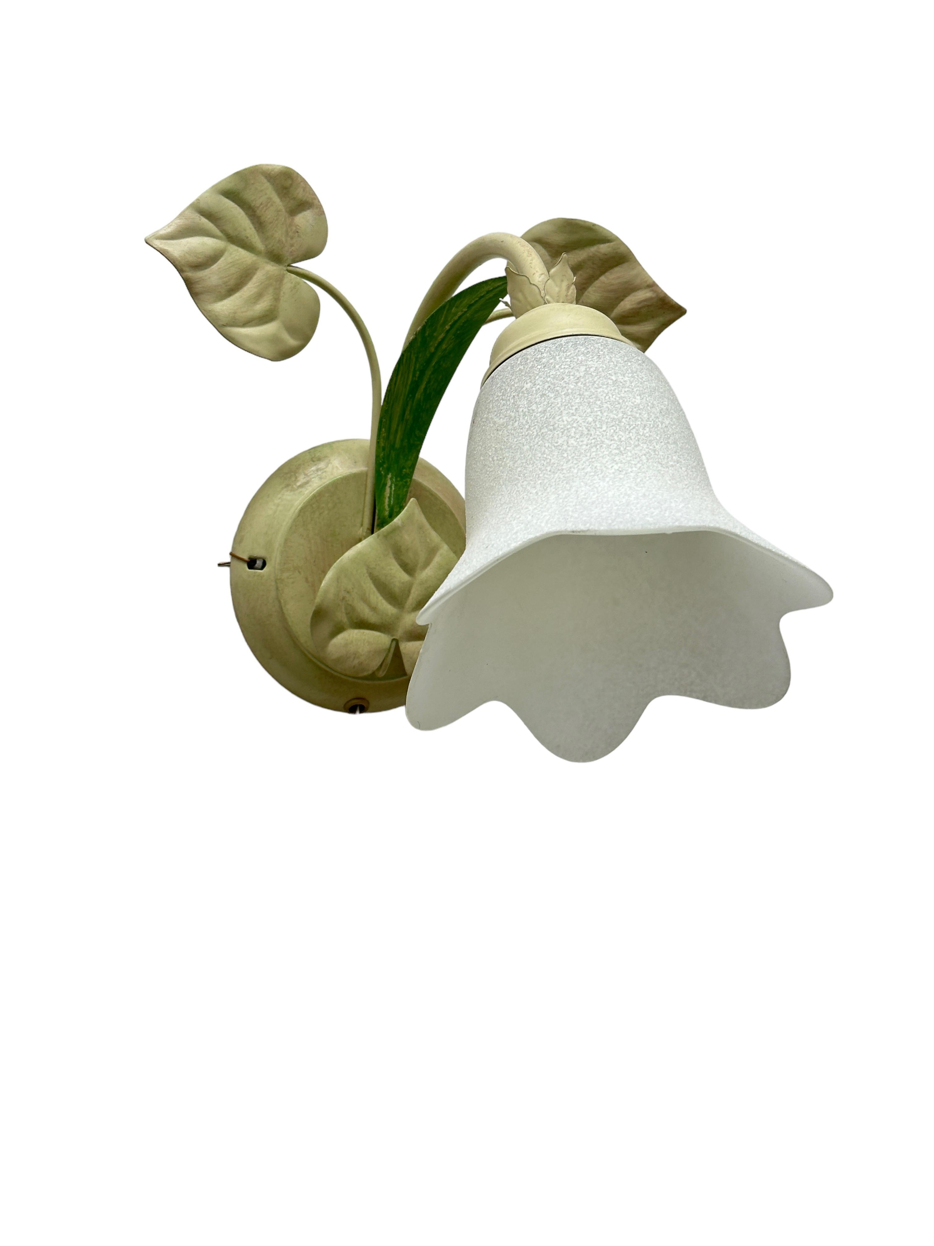 A pair metal floral sconces with glass flower shade. Each fixture requires one European E14 candelabra bulb, up to 40 watts. The wall light has a beautiful patina and gives each room an eclectic statement. Made of metal and glass. Light bulbs are