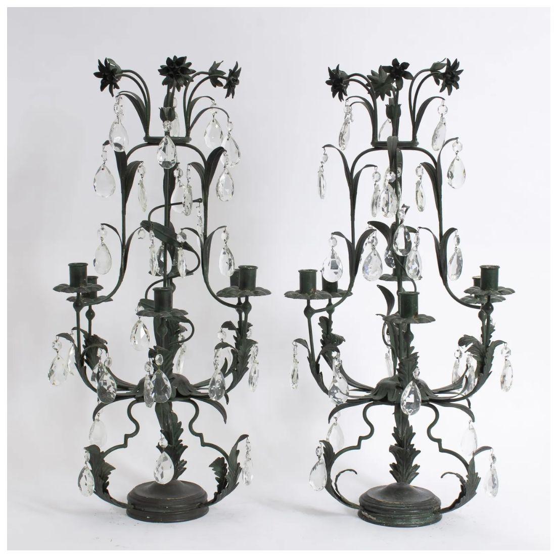 Coppia di candelabri a sei luci in metallo foliato e cristallo a goccia.  Questa coppia decorativa di candelabri neri che reggono sei candele con un motivo floreale e crstili pendenti aggiunge un tocco di estrosità e drammaticità alla tavola.