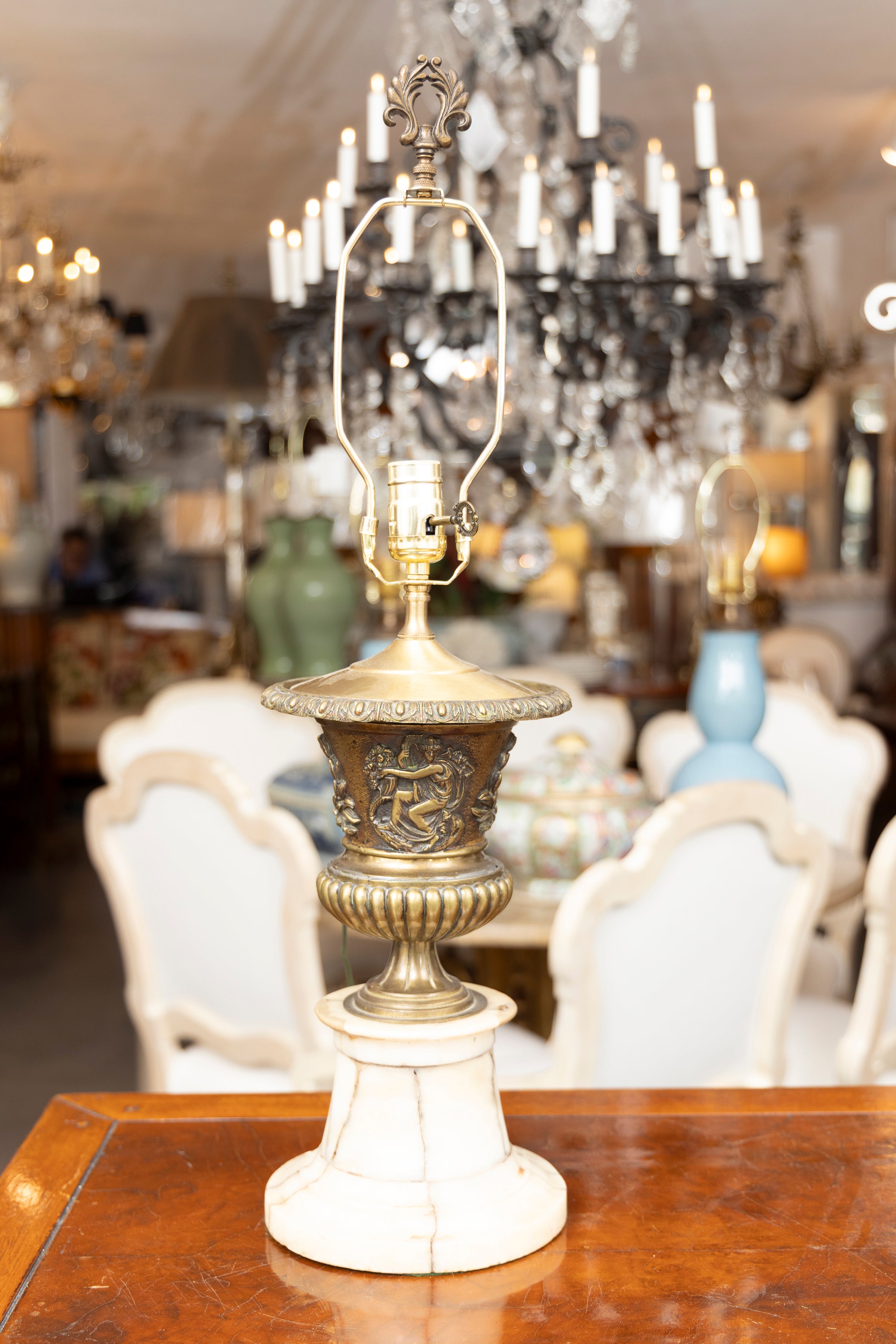 This is a stately pair of 19th century bronzed metal urns with heavy embossing, and situated on a white veined marble plinth