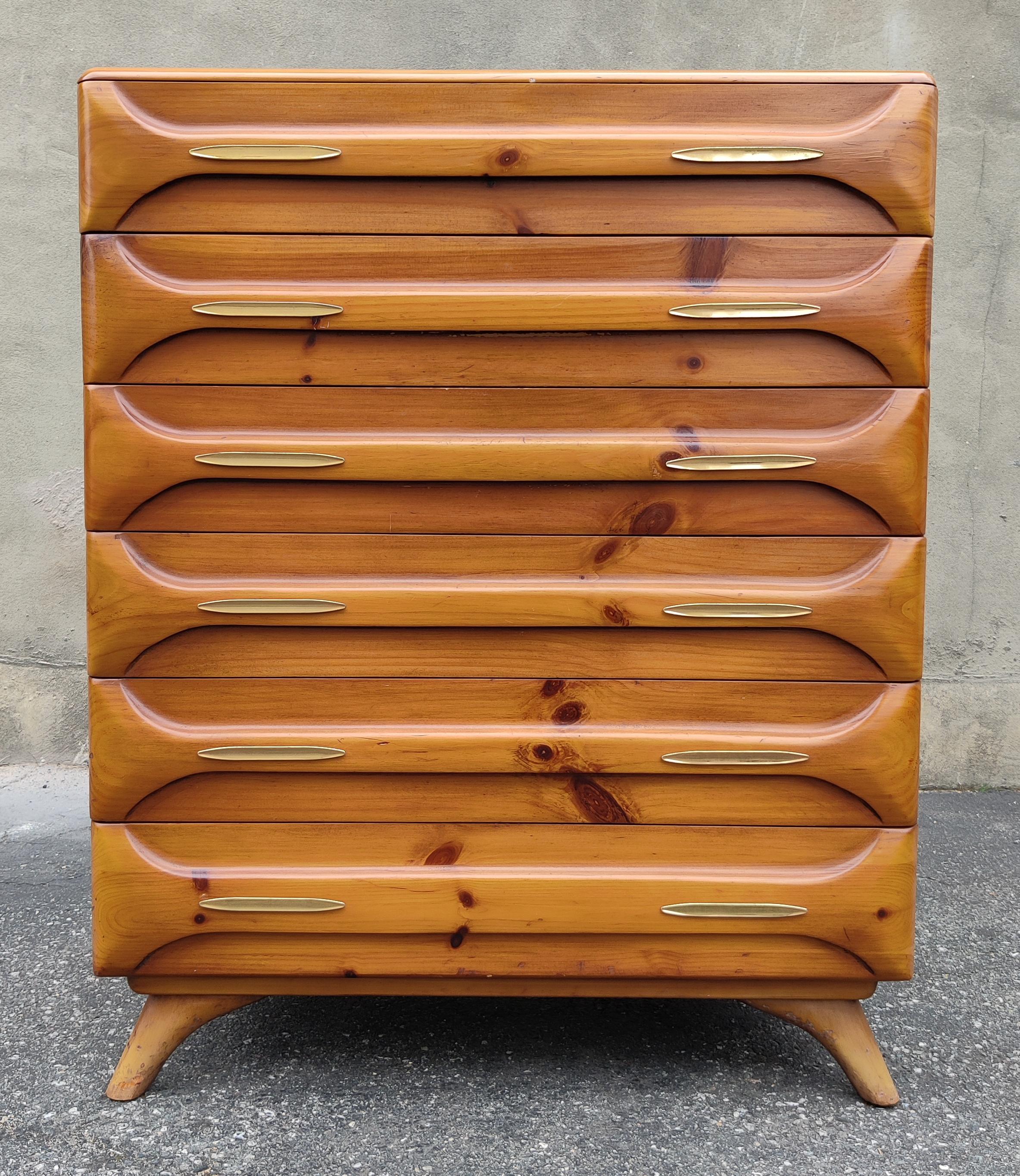 This tall dresser was produced in the 1970s by the Franklin Shockey Company for their Sculptured Pine line of furniture. Featuring solid pine construction, this dresser has a light and warm golden pine color with satin varnished finish. This color