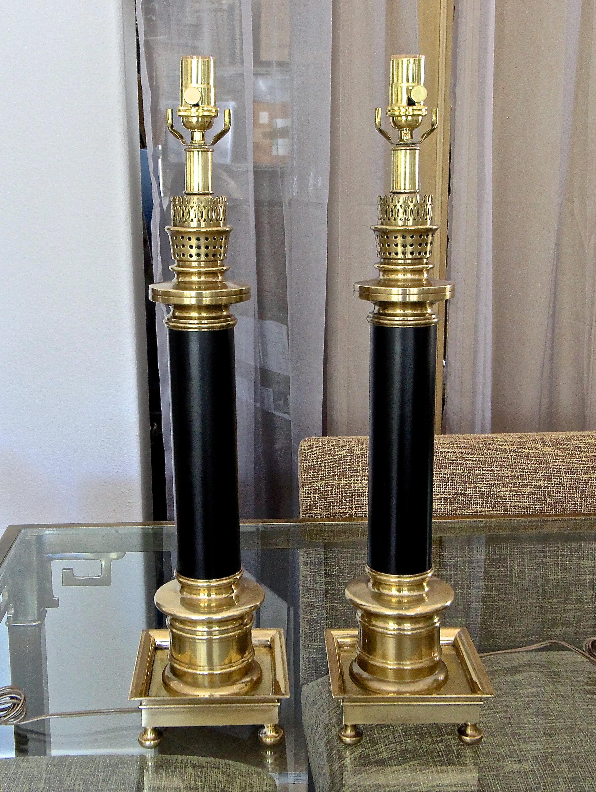 Pair of large solid brass and black painted column table lamps by Frederick Copper for Fitz & Floyd. Newly wired for US with new three-way brass sockets and cords. See photo of replaced socket showing Fredrick Cooper label. Includes original harps