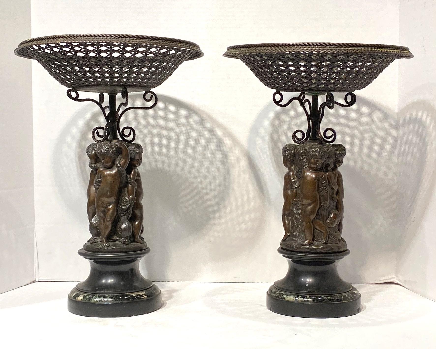 Pair of French 19th century patinated bronze  corbeilles depicting cupids on marble bases.