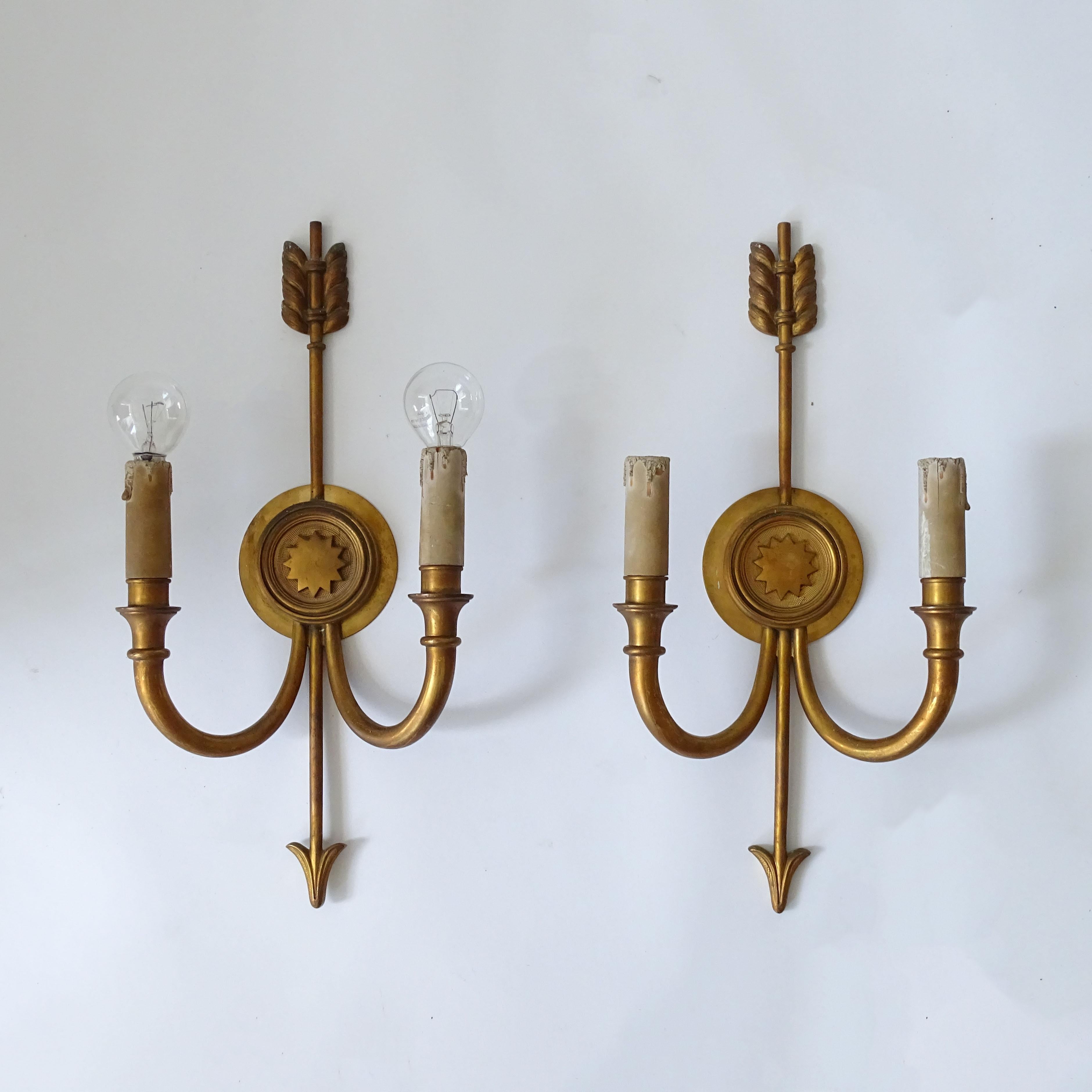 Pair French 1940s Neo-classic arrow-shaped brass wall lamps
carries two lights per lamp.