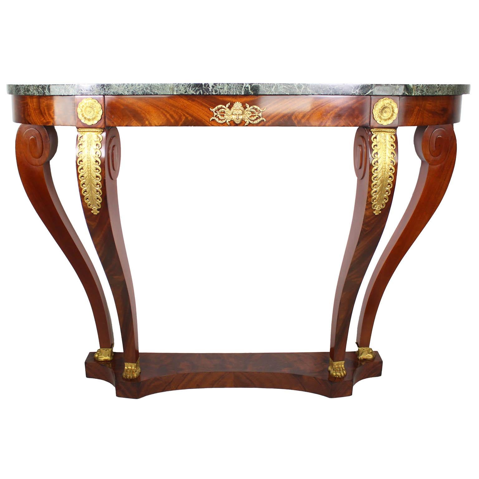 A Fine Pair of French 19th/20th Century Empire Revival Style Exotic Mahogany Marquetry and Gilt-Bronze Wall Mounting Demi-Lune Consoles fitted with green d'Alps marble tops, attributed to Maison Forest, Paris. Circa: Paris, 1890-1900.

Maison