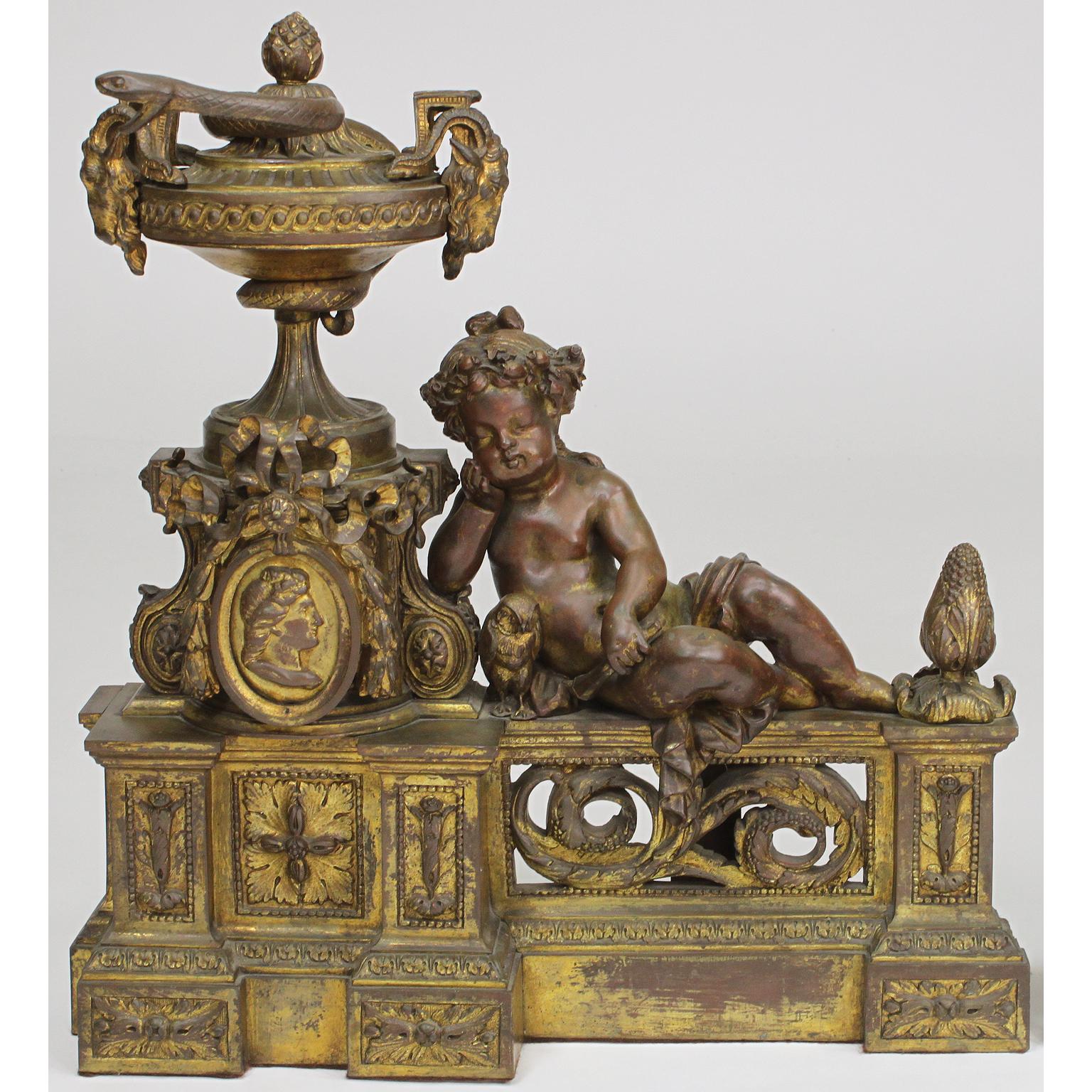 A fine pair of French 19th century Louis XV style gilt-bronze mounted figural chenets. The ornately decorated andirons, each with a figure of a resting Putto (Children) holding a torch flanked by a bird and an allegorical urn with ram-handles and