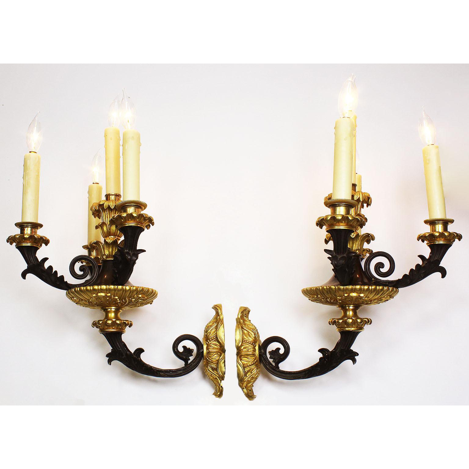 A fine pair of French 19th century neoclassical empire revival style gilt and patinated bronze four-light wall sconces (wall lights). The ornately chased bronze candle-arms with an acanthus-leaf design protruding from a gilt-bronze medallion and a