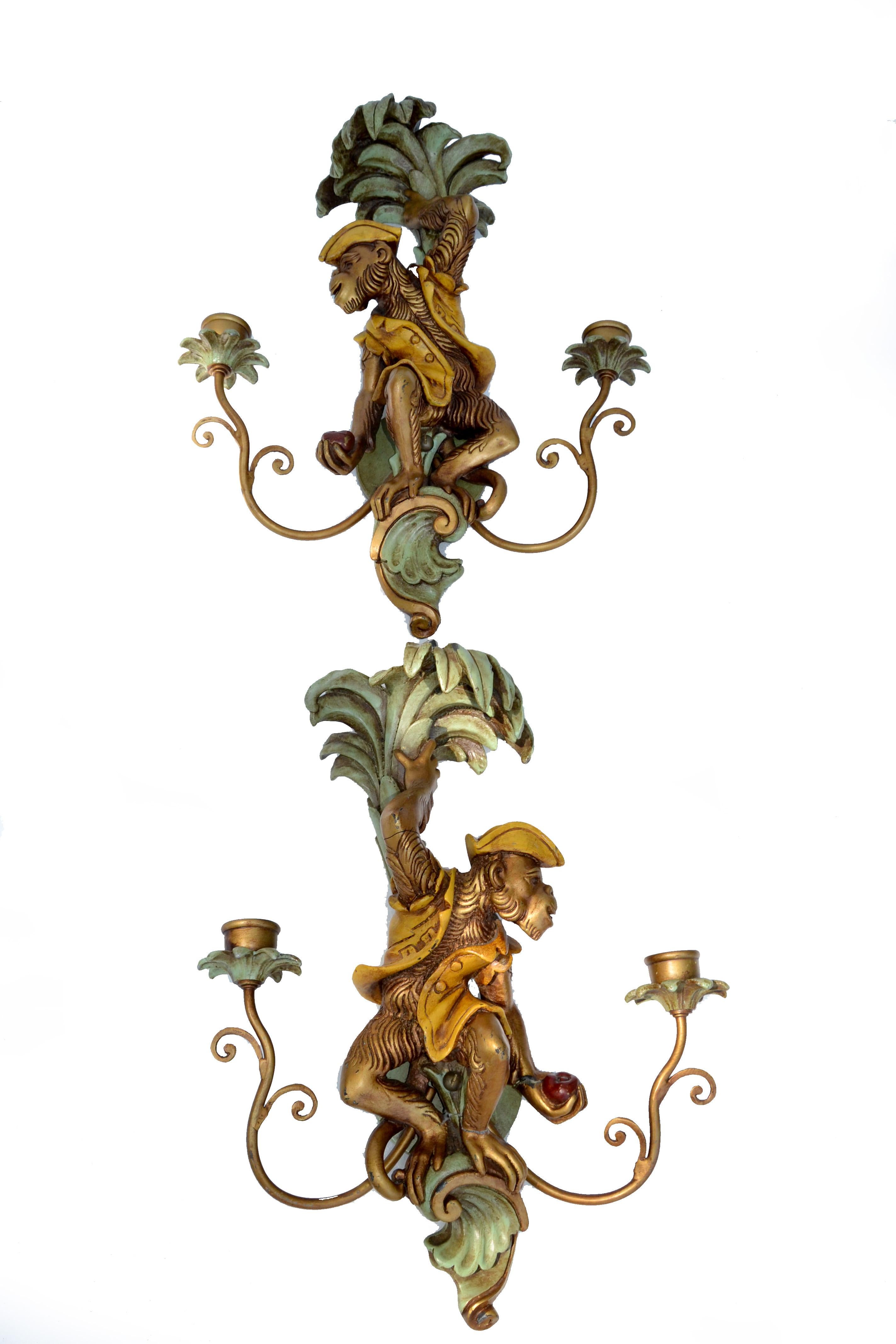 One of a Kind pair of non-electrified 2 candles hand-carved wood Sconces depicting a Monkey holding onto a Palm Tree and having a red Apple in his hand. 
Each Sconce is the exact Mirror Image of each other. Great Animal Sculptures.
Round Back