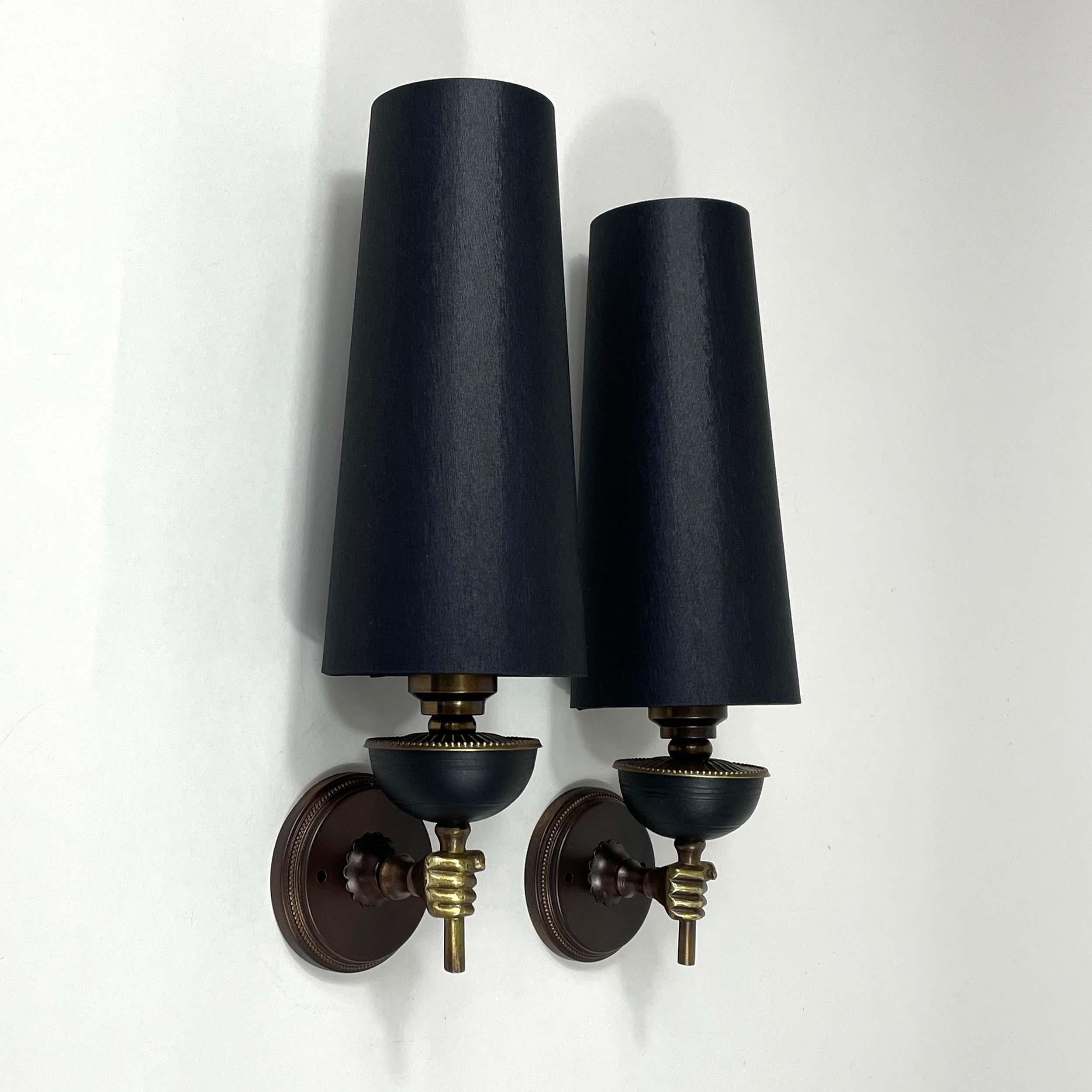 These unusual vintage sconces were designed and manufactured in France in the 1950s. They feature brass / bronzed torchiere lights with (new) hand made black silk fabric lamp shades.

Wired for use in US, Europe and Asia the lights require one E14