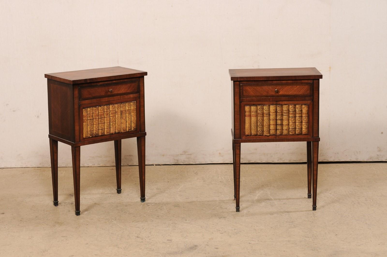 A French pair of raised side chests with leather book designed fronts, from the early 20th century. These antique side chests from France each feature beautiful book-matched veneer tops over a case which houses a single drawer over a pair of doors