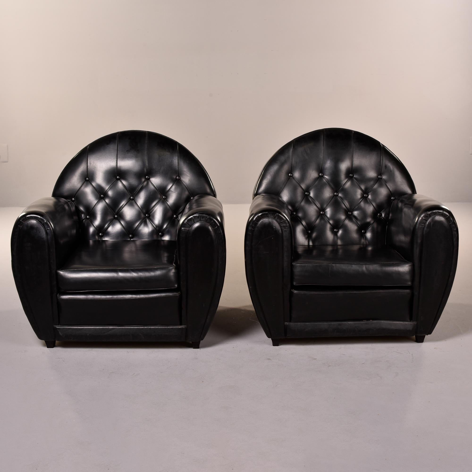Pair of circa 1940s French club chairs in black leather. Chairs have button-tufted rounded backs, curved arms, and removable seat cushions. Very good overall vintage condition with original leather showing some scattered wear. Unknown maker. Sold