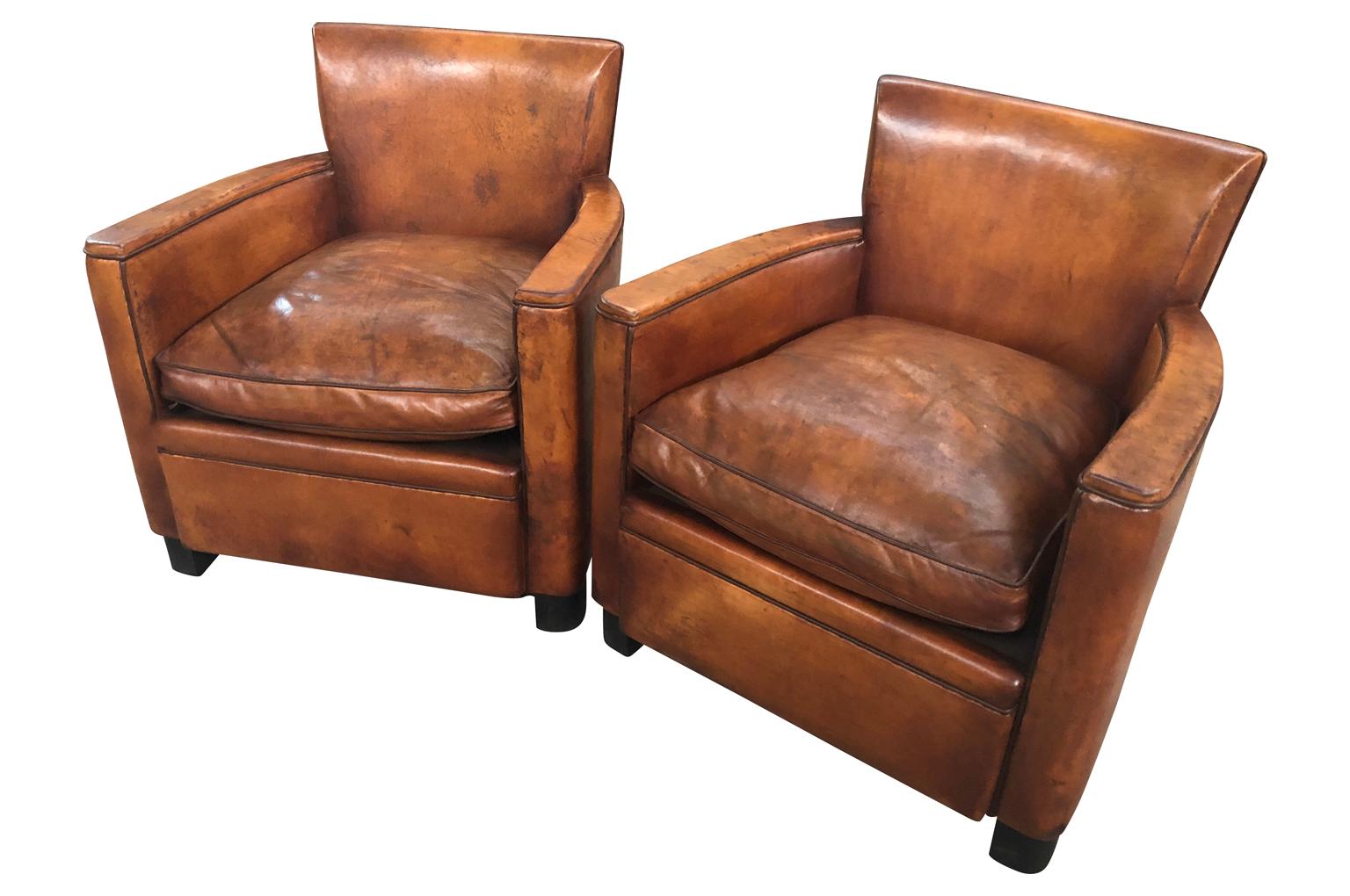 A very handsome pair of mid-20th century Art Deco style club chairs. Constructed with a very minimalist design in beautiful leather and very comfortable. Measures: Seat height 17 3/4