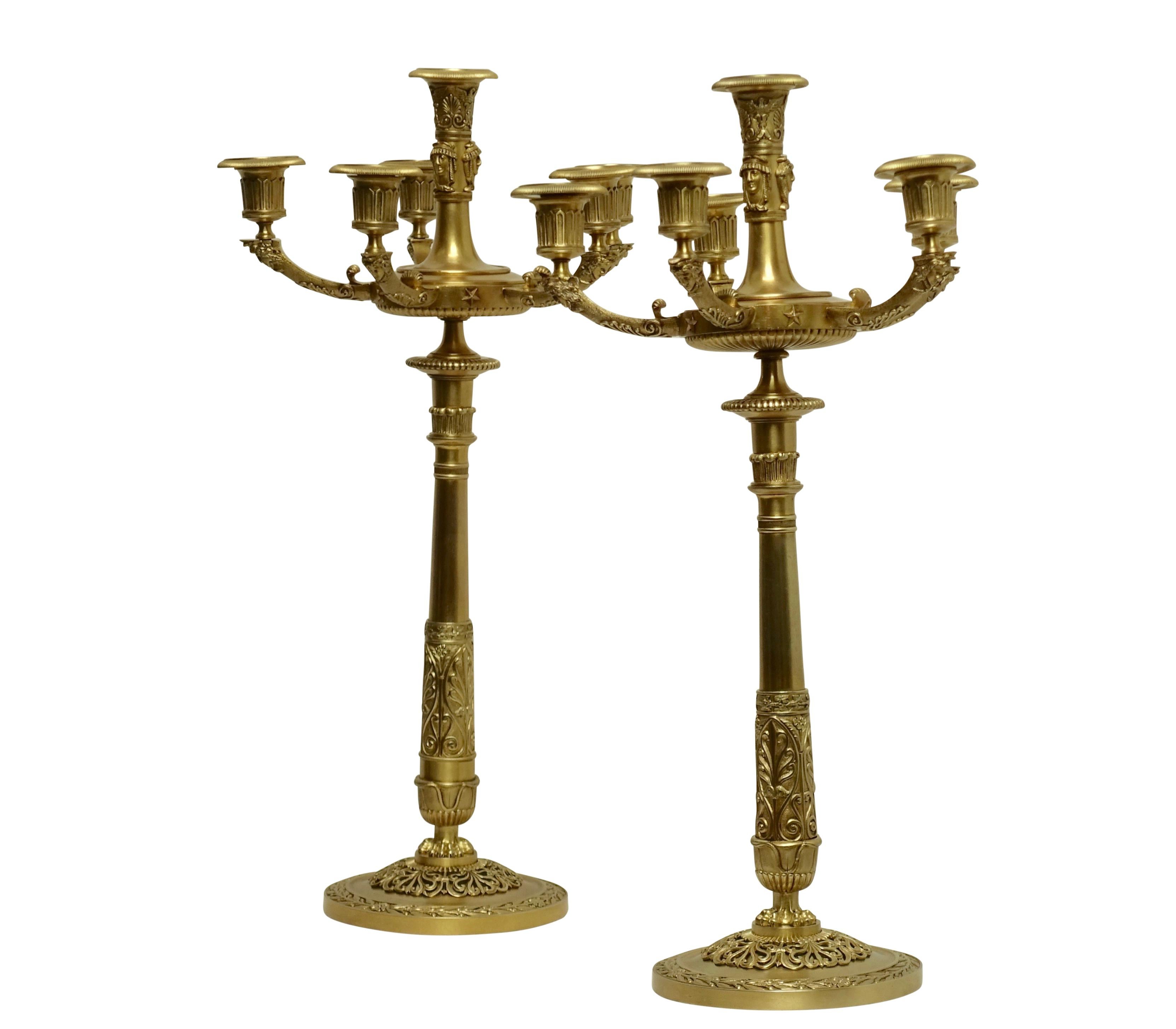 A pair of fine quality Egyptian Revival bronze candelabra with Egyptian masks around the centre candle cup and five arms with the additional candle cups. These had been electrified sometime in the first quarter of the 20th century, France, circa
