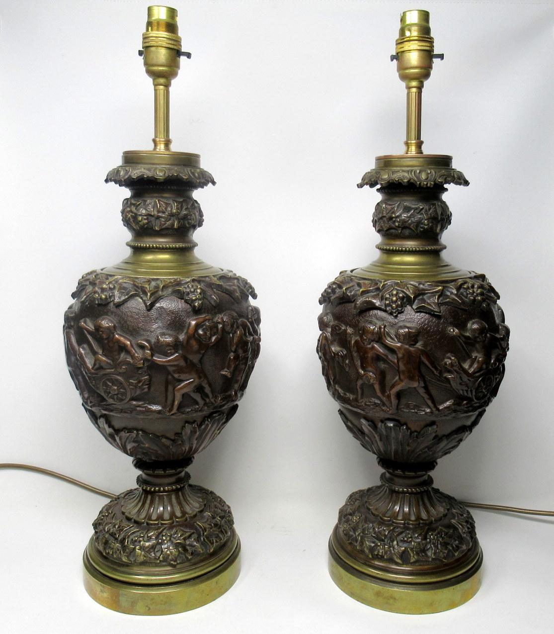 Fine pair of large heavy French bronze oil lamps in the manner of Claude Michel Clodion of outstanding heavy gauge quality, now converted to electricity, first quarter of the 19th century. 

Each with tapering ovoid bodies cast with a Bacchic