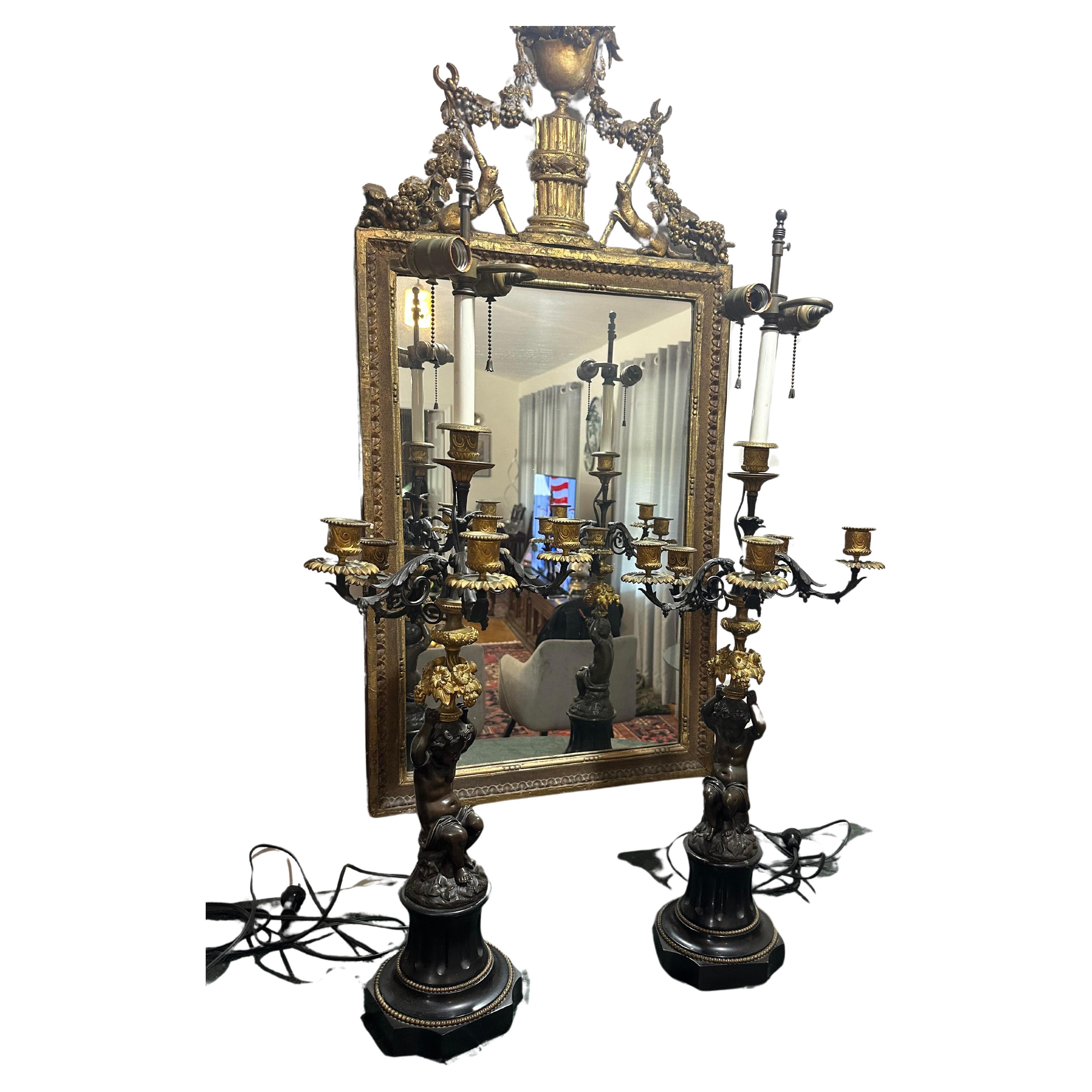 Se trata de un magnífico par de lámparas querubín de bronce macizo y pizarra alambrada americana de estilo neoclásico. Los puttis están fundidos con maestría y presentan detalles realistas que evocan todo el romanticismo de los primeros periodos