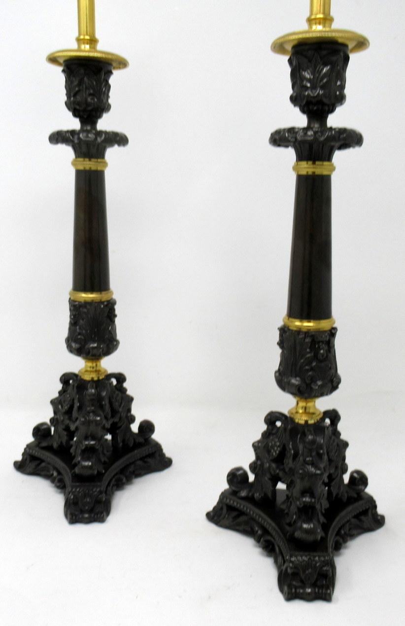 Stunning pair of French heavy gauge ormolu and bronzed single light candlesticks of good size proportions, now converted to electric table lamps, of nice tall proportions, each with tapering plain smooth central bronze columns, ending with three