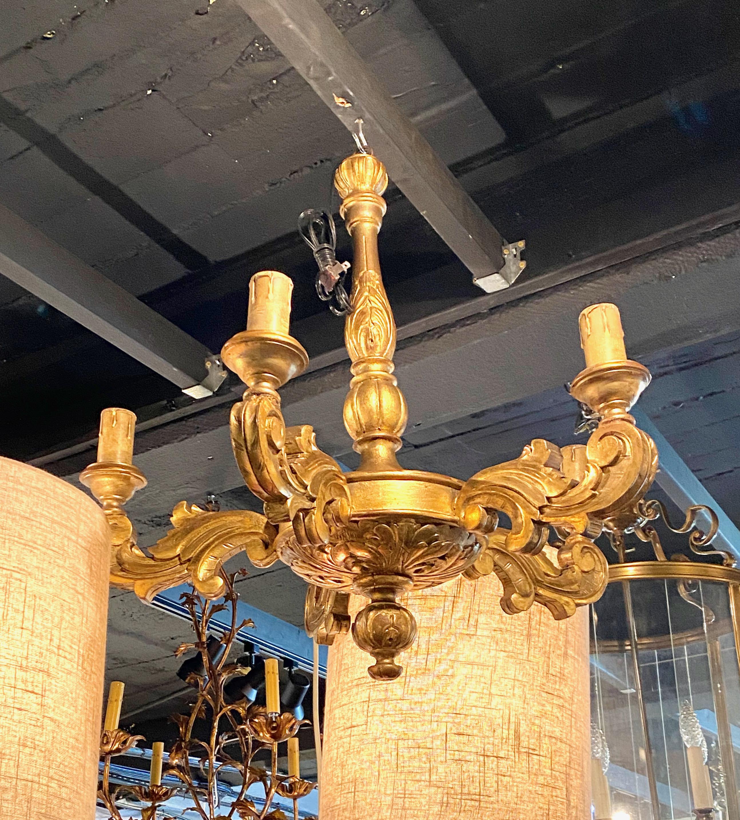 This is a good example of a late 19th/early 20th century pair of French 5-arm carved and gilt chandeliers. It is unusual to find a matched pair of chandeliers; so these are a true find.The chandeliers are in the Baroque style, retaining their