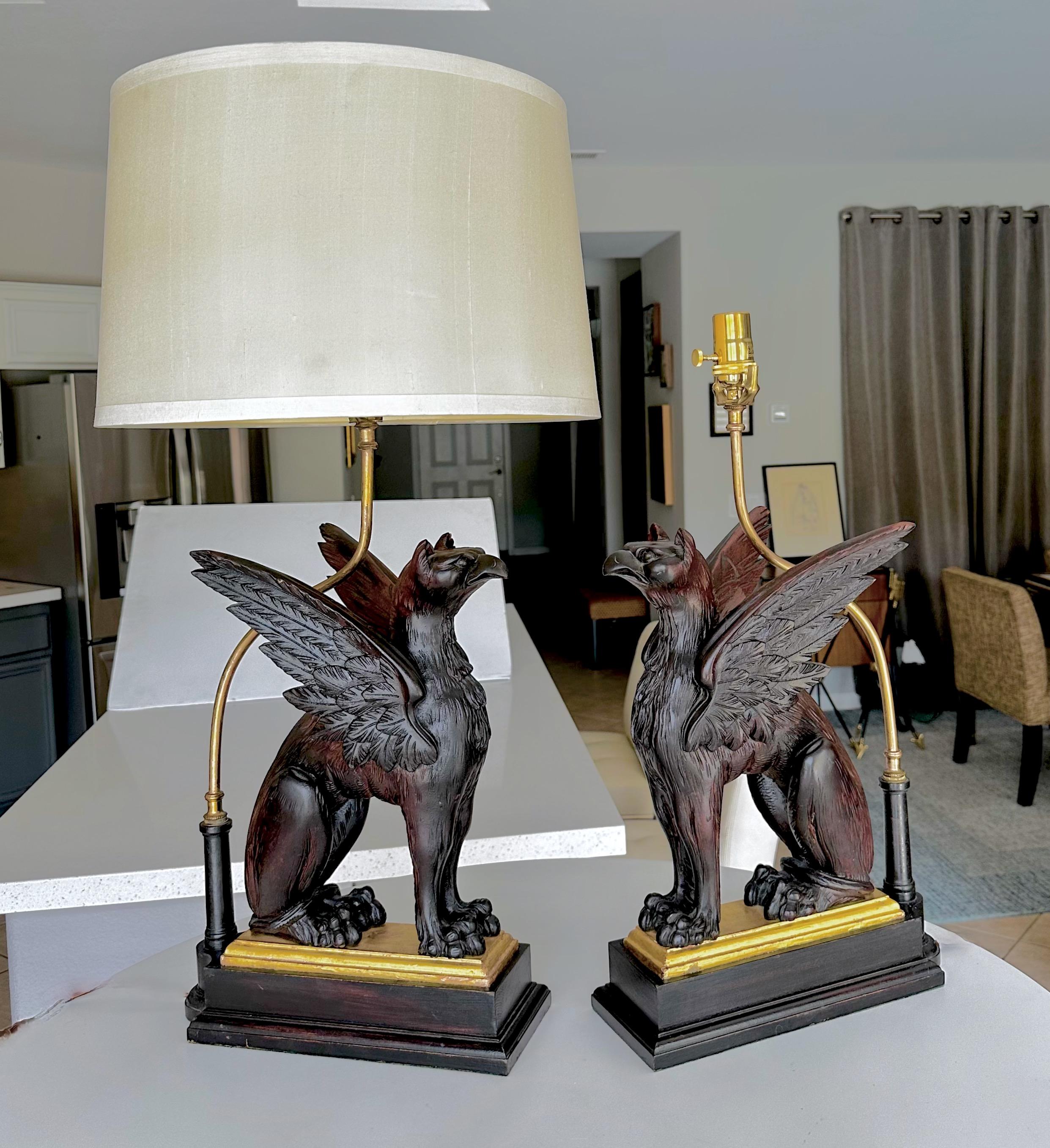 Paire de griffons mythologiques en bois sculpté, montés comme lampes sur des bases partielles en bois doré. Sculpture experte sur l'ensemble de la pièce. Nouvellement câblé pour le marché américain avec de nouvelles prises à 3 voies en laiton et des