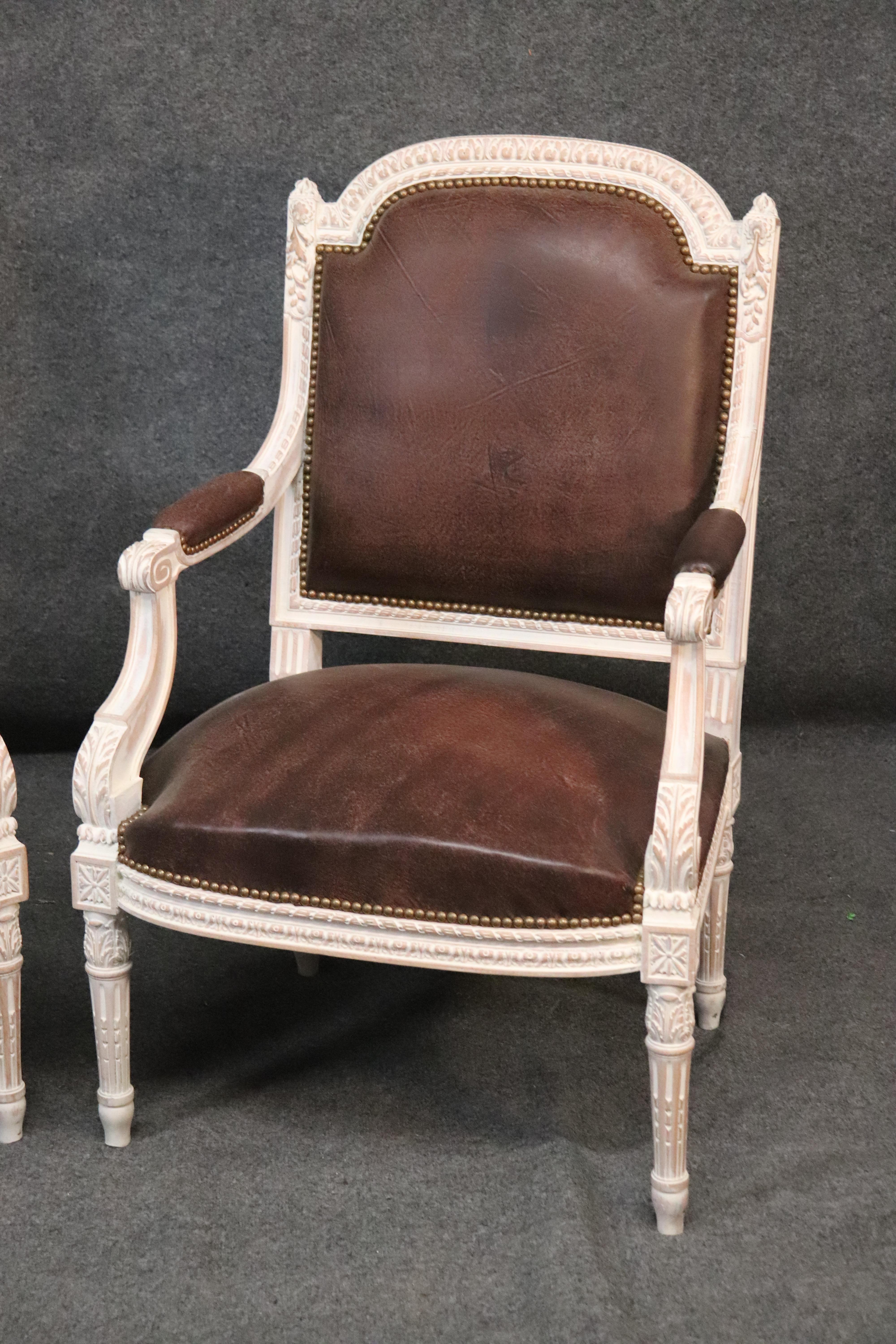 This is a fine pair of genuine chocolate brown natural top-grain leather arm chairs in the Louis XVI style the chairs are in excellent condition and have no damage or issues. They each measure 40 inches tall x 26 wide x 25 deep and the seat height