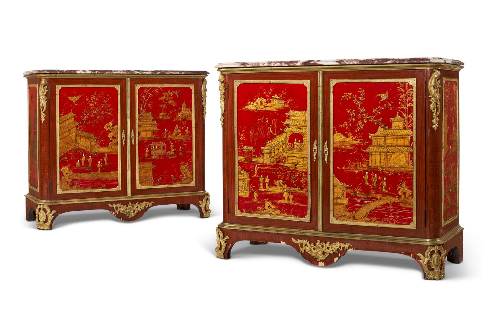 Our fabulous pair of French chinoiserie side cabinets with mahogany veneer feature ormolu bronze mounts and carved red lacquer panels on the doors depicting palaces and courtyard scenes, and side panels depicting landscapes with flowers and birds.