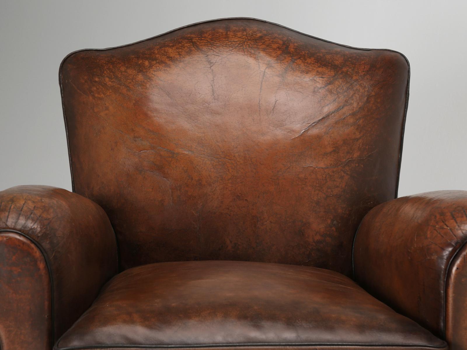 Pair of French Art Deco club chairs still wearing their original leather. The French club chairs have been correctly and painstakingly restored from the bottom up, while using old-school methods. Each and every French club chair that we offer for