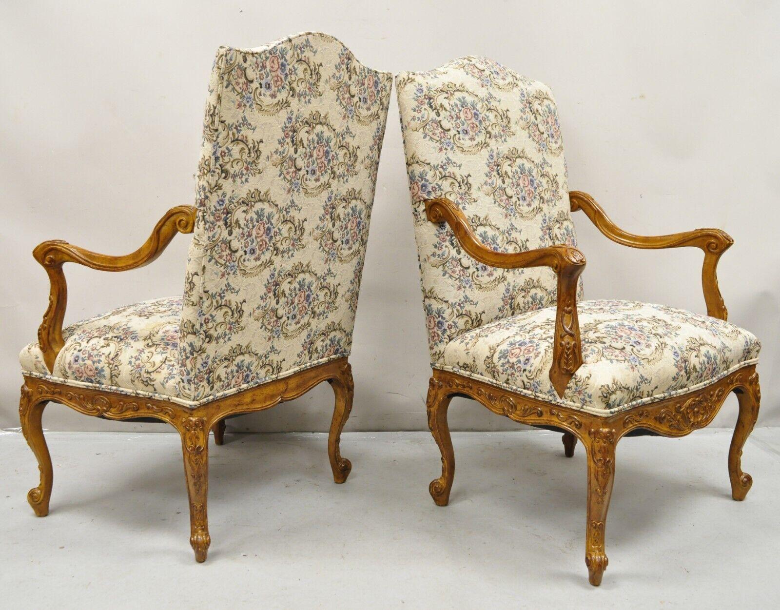Pair French Country Style Carved Walnut Floral Upholstered High Back Arm Chairs. Item features a solid wood frame, fully upholstered back and seat, distressed finish, nicely carved details, quality craftsmanship, great style and form. Circa Late