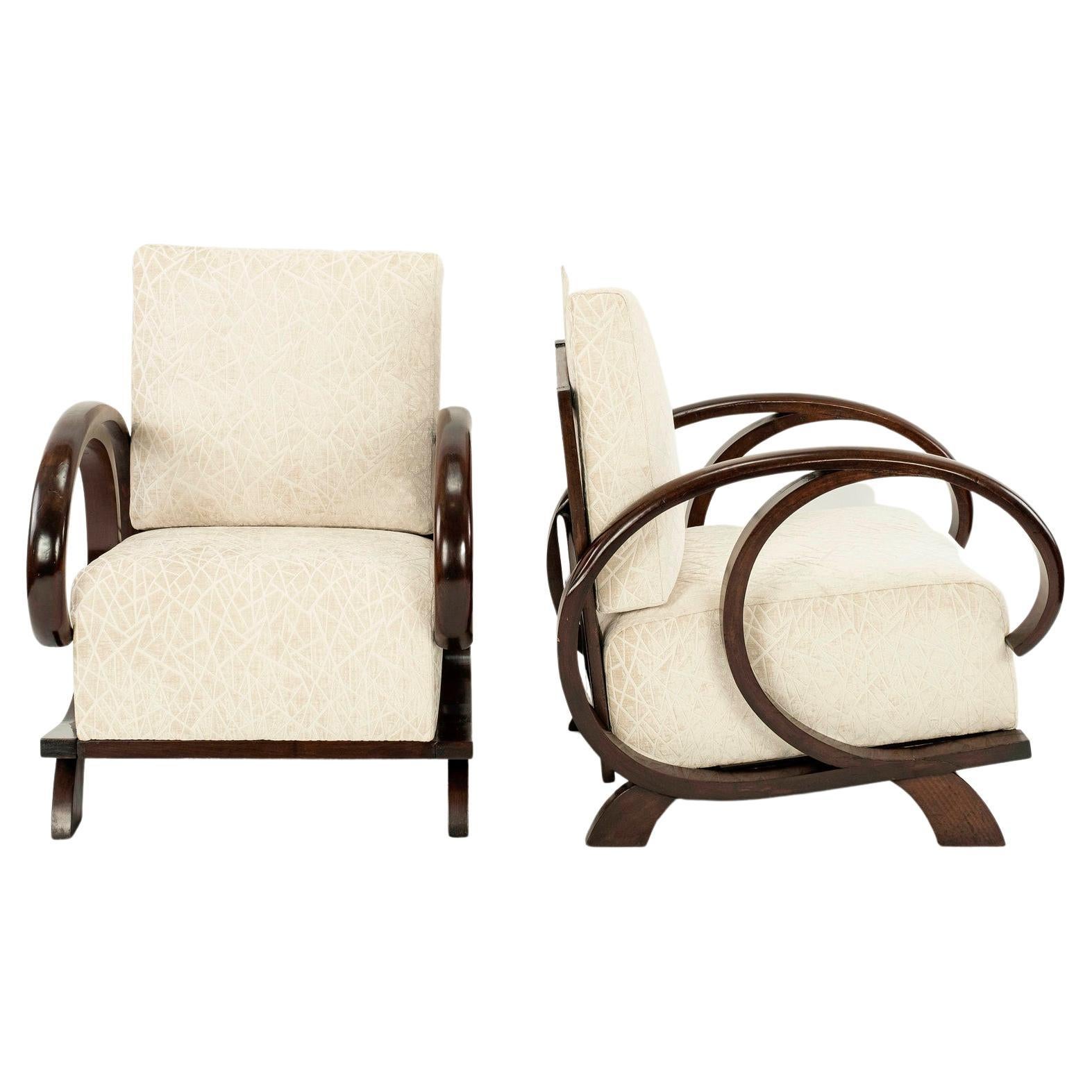 A pair of French Deco walnut stained hardwood lounge chairs newly upholstered in an ivory cut chenille velvet.
 
