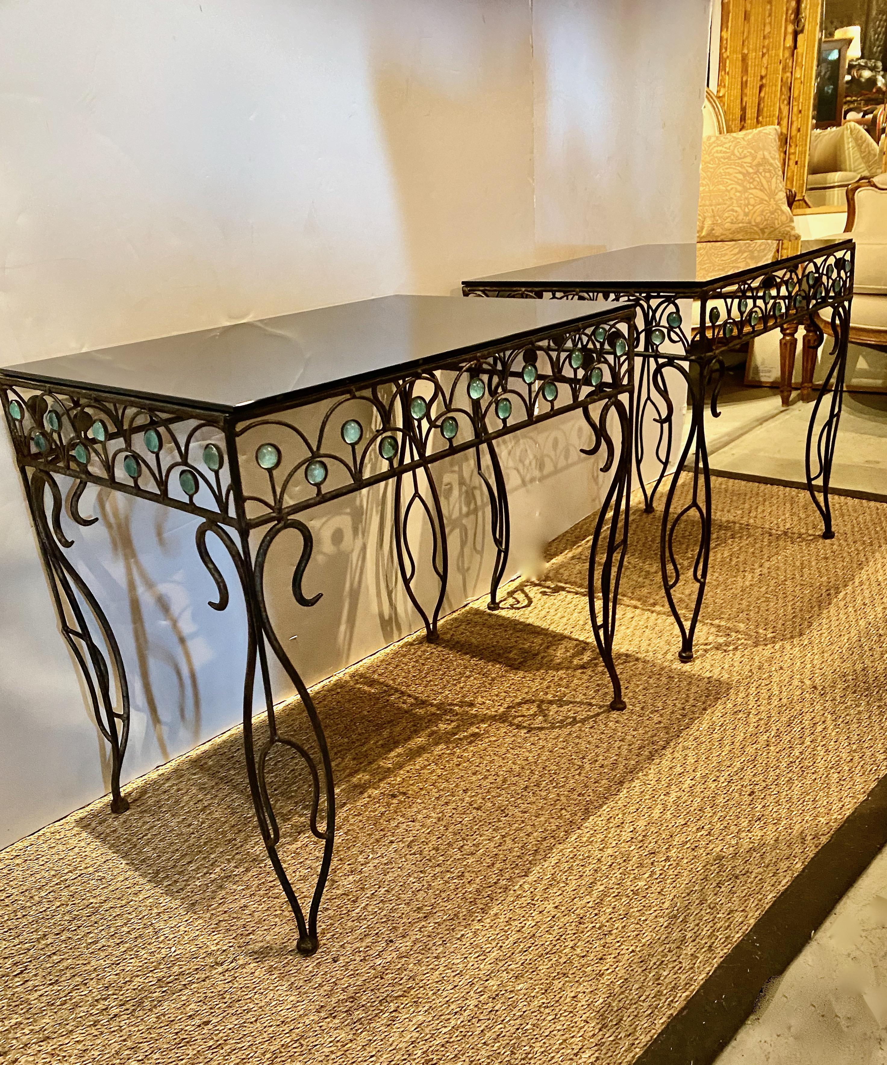 This is a unique pair of period French Art Deco side tables. The wrought iron tables are finely detailed in an iconic Art Deco arch motif with blue murano glass embellishments. The legs are fanciful with an unusual sinuous design. We have added a