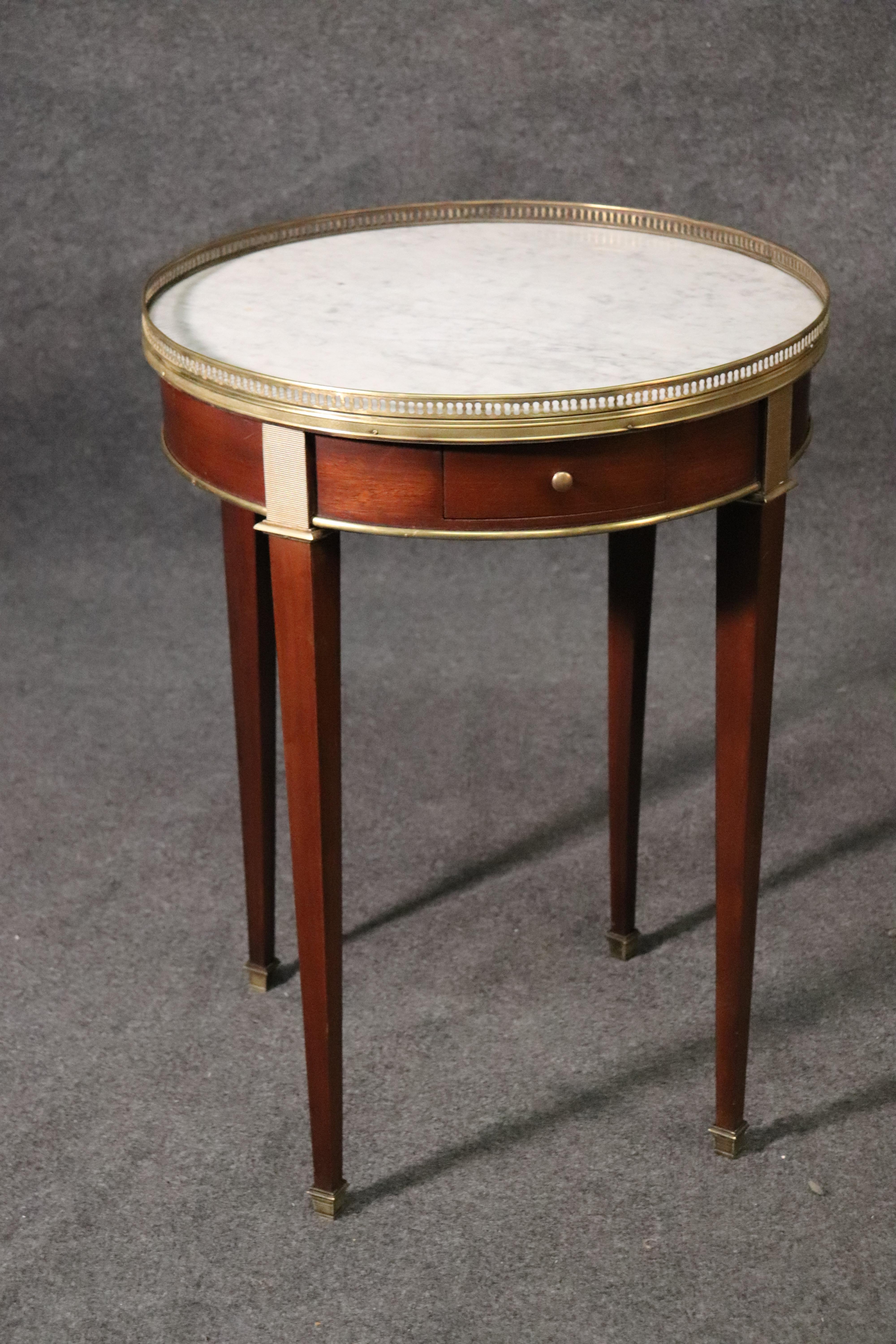 This is a fantastic pair of French geuridons or end tables that are in good condition with white Carrara marble tops and measure 29.25 tall x 22 wide x 22 deep. The tables date to the 1960s era and are fitted with beautiful brass ormolu.