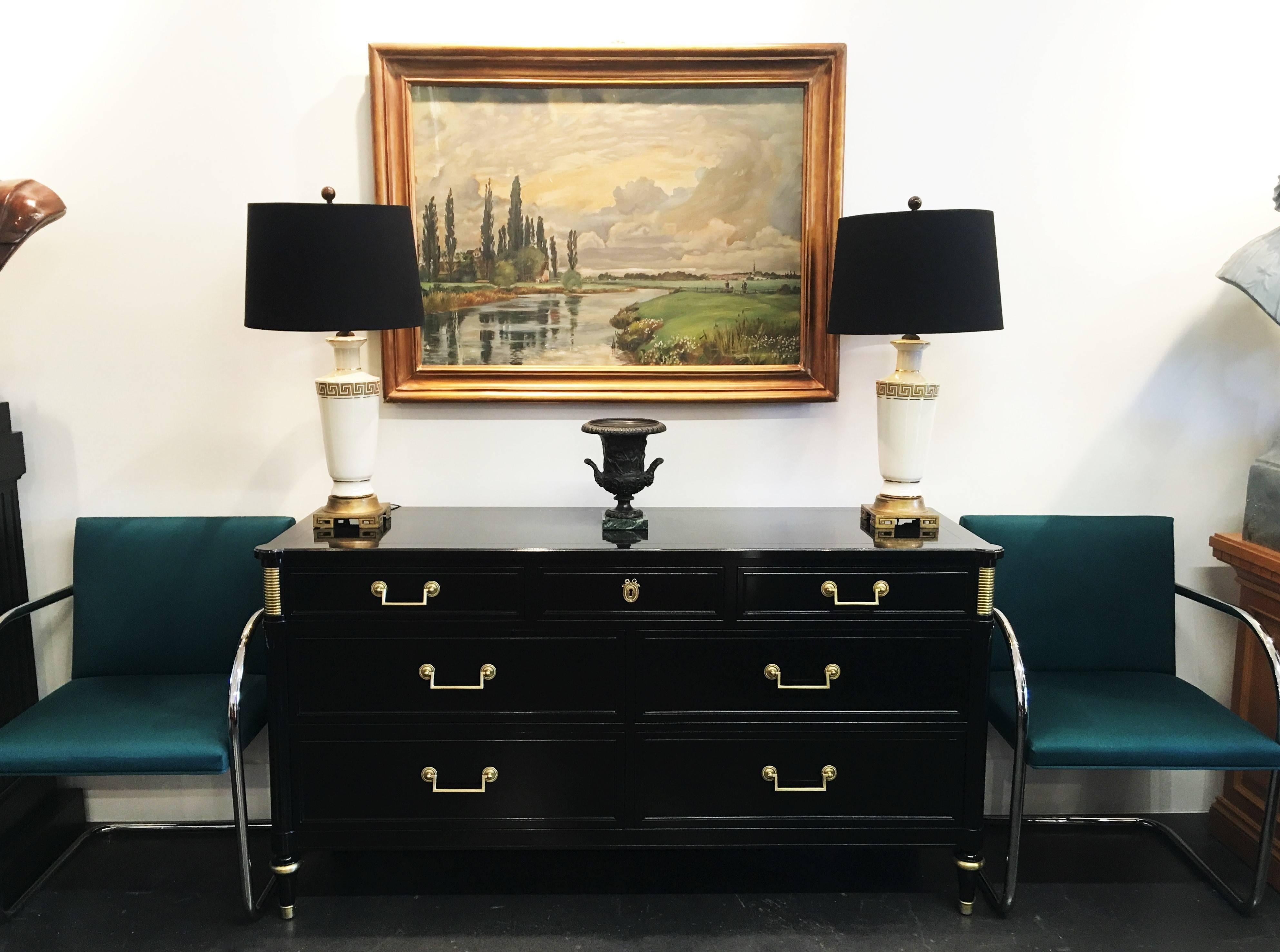 French Directoire style ebonized commodes, circa 1940s. The rectangular top over a conforming case fitted with seven drawers, each drawer is decorated with brass hardware, supported on four circular fluted legs with brass accents, raised on four