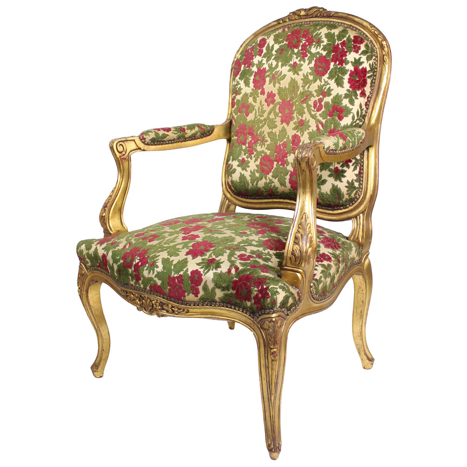 A Pair of French Early 20th Century Louis XV Style Giltwood Carved Fauteuils Armchairs. The open-armed armchairs, with upholstered backs and seats, the top carved with a floral design and supported on four cabriolet legs. Circa: 1920

Height: 40 1/2