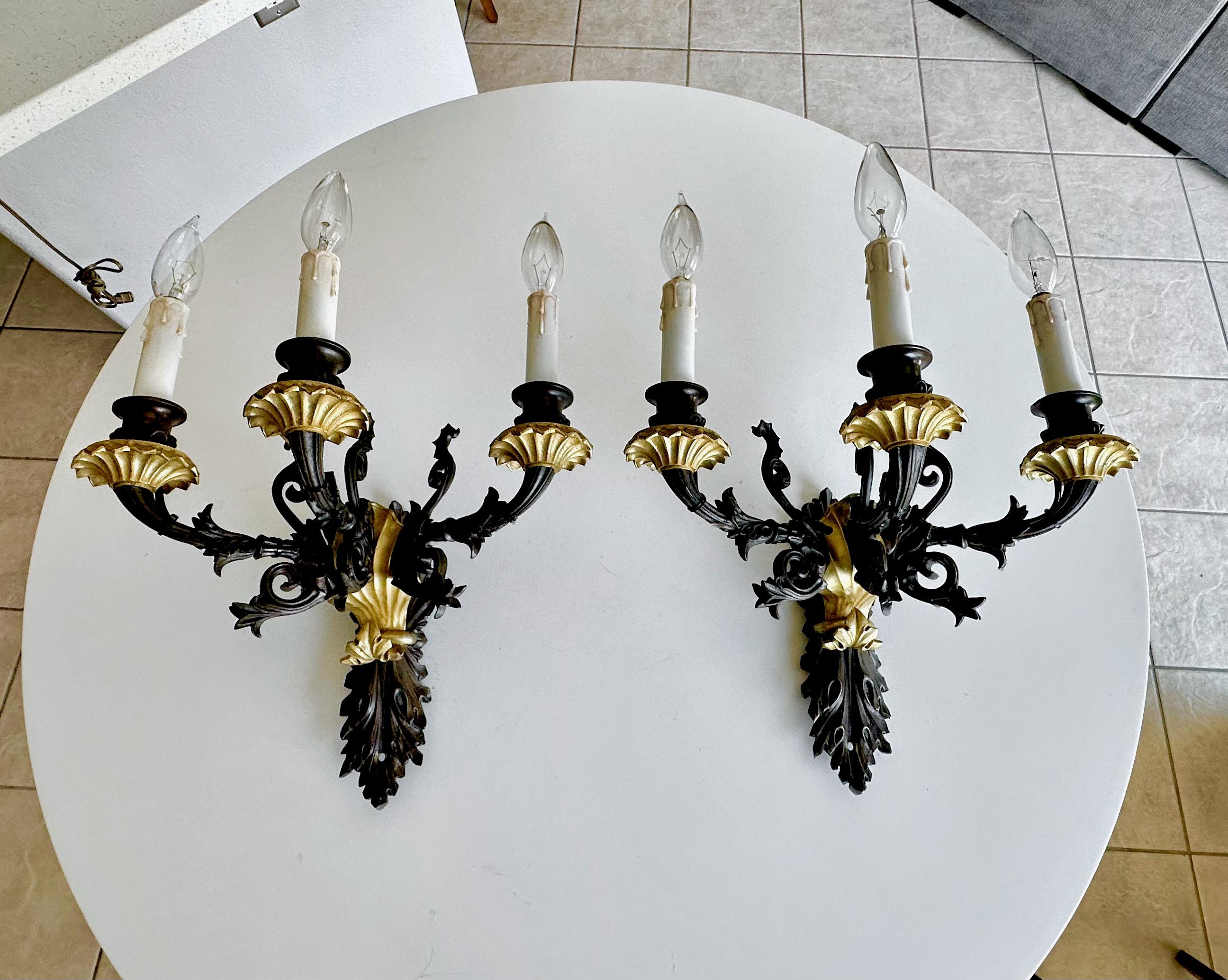 Pair of patinated bronze Empire-style wall sconces made in France in the late 19th Century. These are made of quality bronze and D'ore gilt touches  including the bobeches and other details. The sconces feature 3 arms and each include a candelabra
