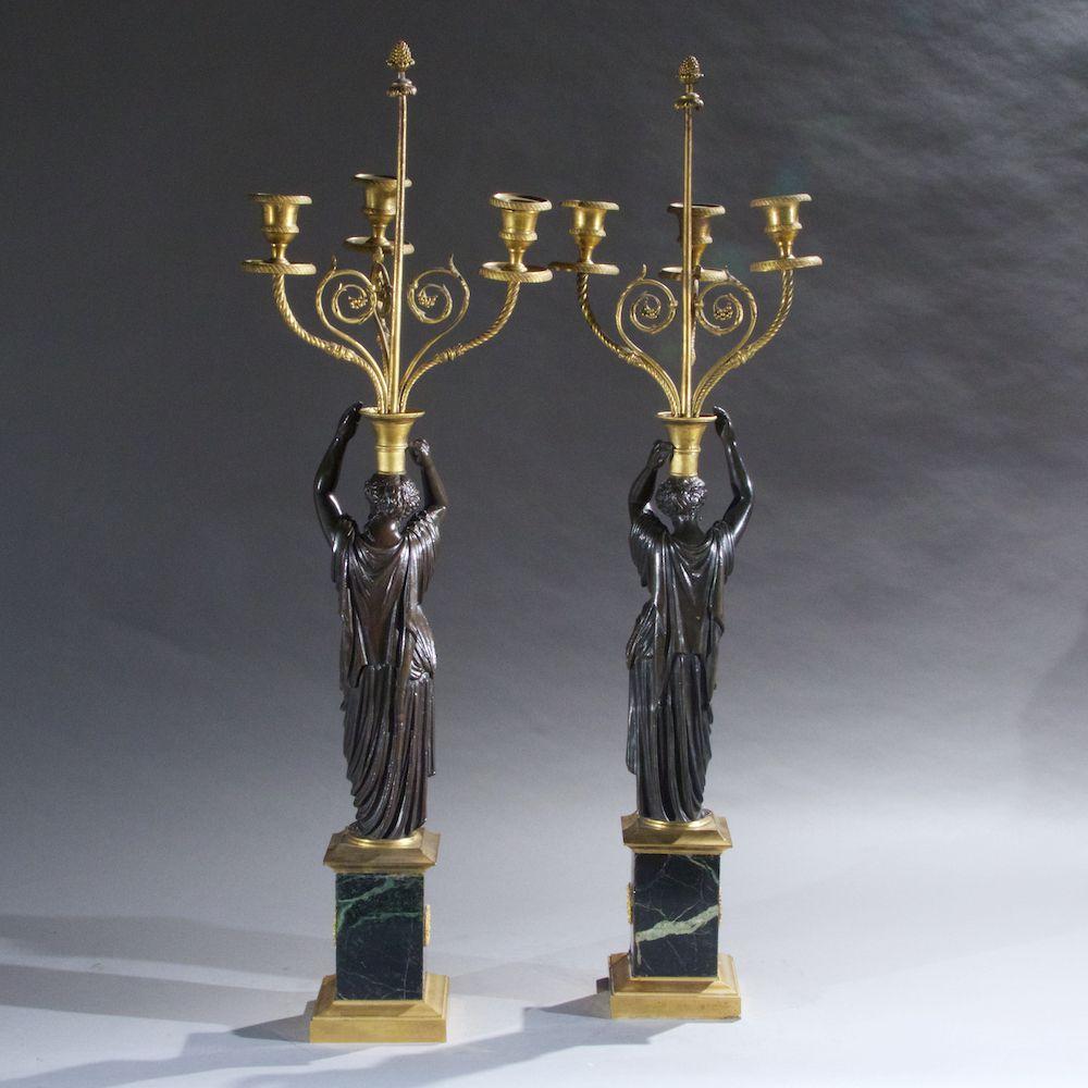 Pair of 19th century gilt and patinated bronze figural Empire style candelabras on marble bases.