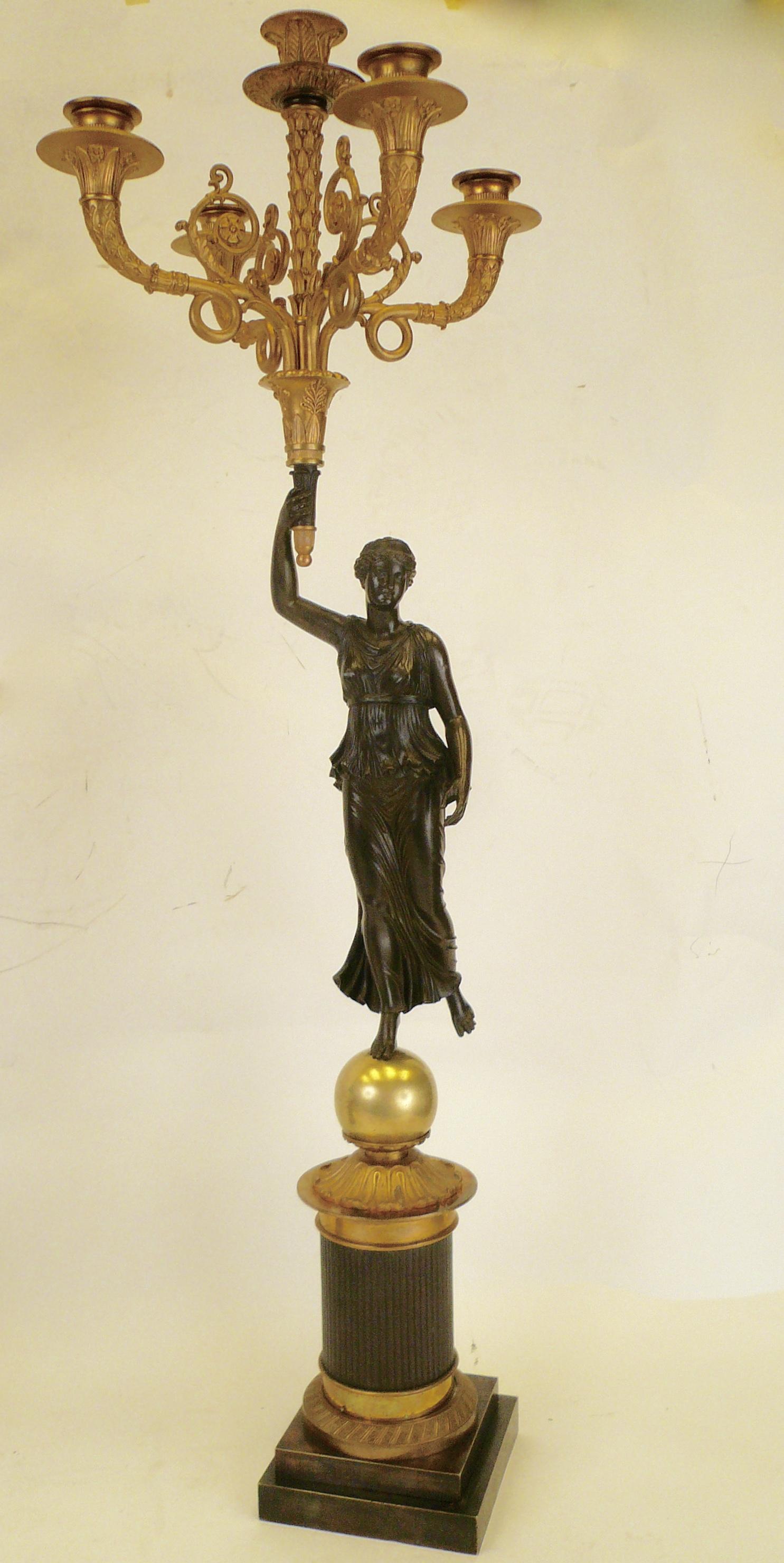 These signed French Empire figural bronze candelabra are by the esteemed maker Claude Francois Rabiat, 1756-1815. The figures represent Nike the goddess of victory, and the casting is extremely detailed and beautifully finished in patinated bronze.