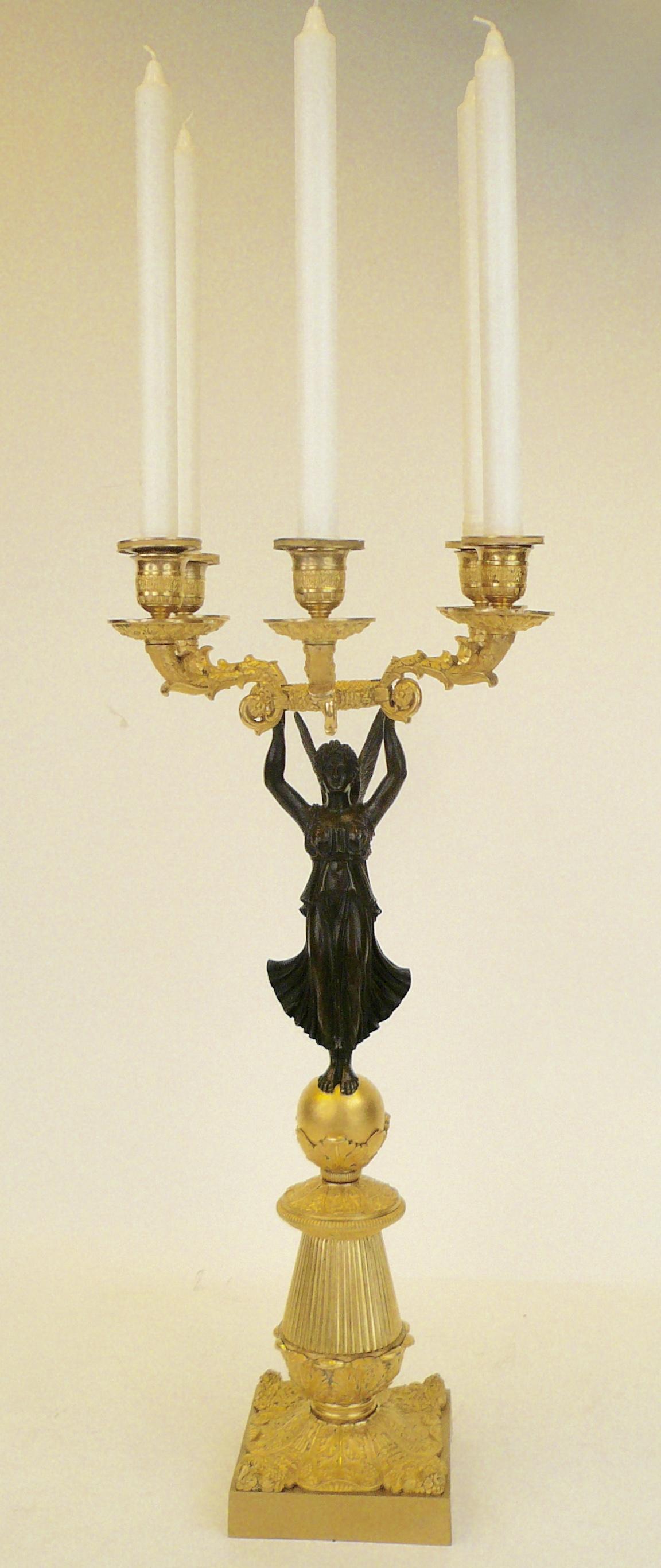 This pair of patinated and gilt bronze neoclassical candelabra are hand chased, and finely detailed.
They feature a patinated figure of the goddess of victory holding a floral wreath aloft, and five candle arms.



 