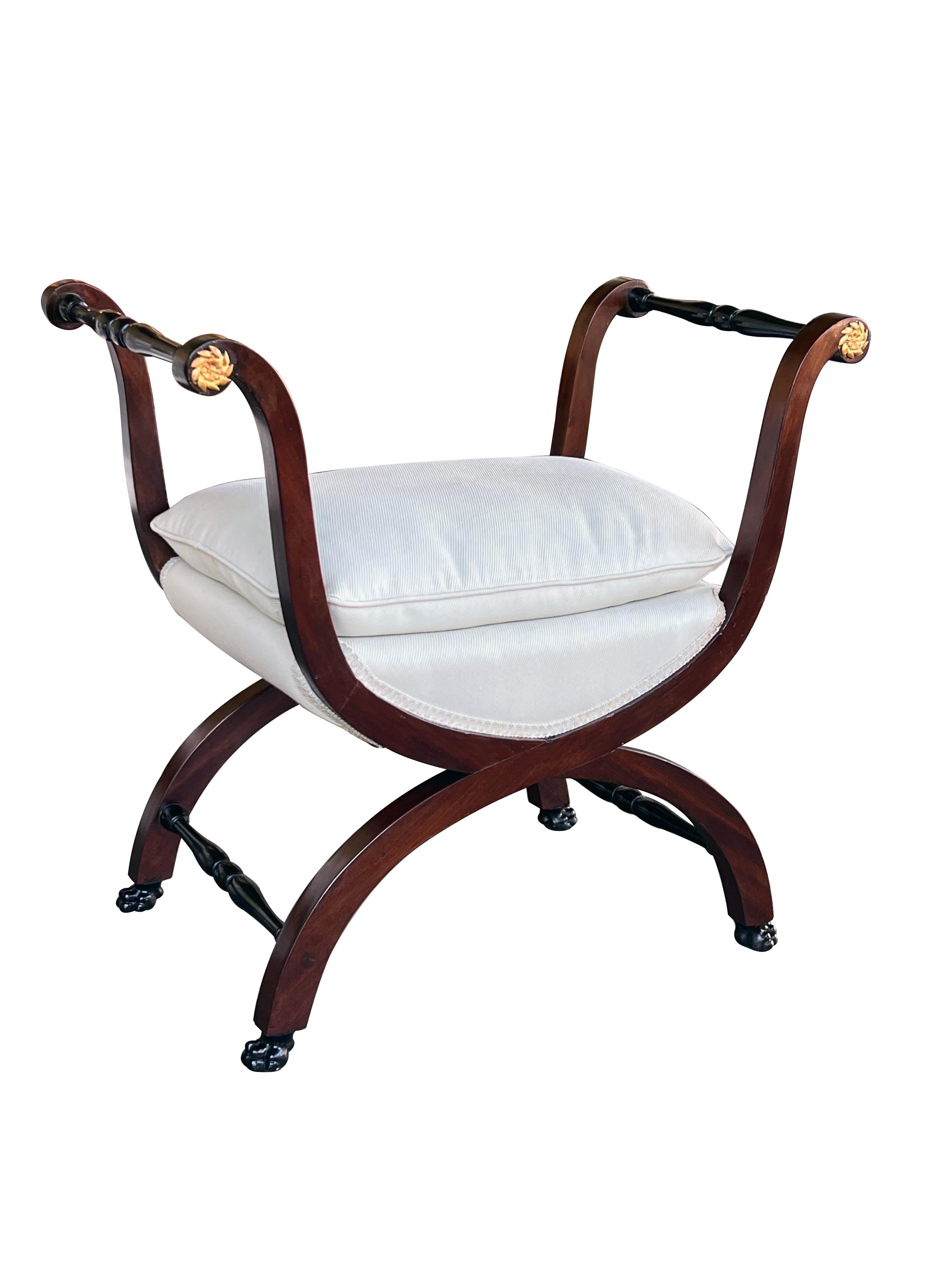 each large-scaled curule bench with semi-detached seat flanked by flared openwork arms with turned double-baluster stretchers; all raised on down-scrolled supports ending in paw feet all joined by turned stretchers