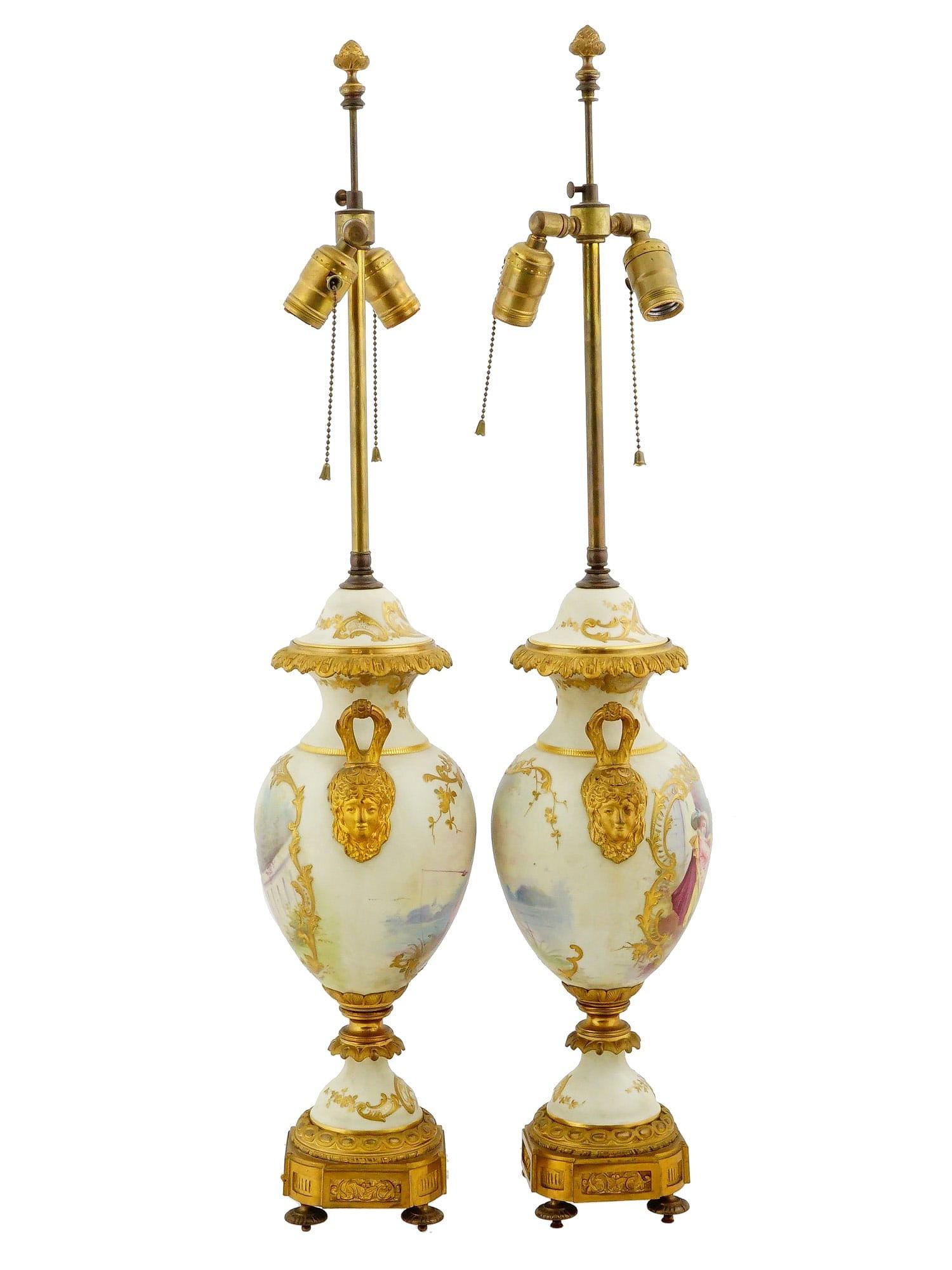 
Pair of antique (late 19th century) French gilt bronze mounted parcel gilt porcelain vases in the Louis XV Sevres style, electrified late 19th to early 20th century, featuring finely painted scenes in the Rococo style depicting couples in courtship