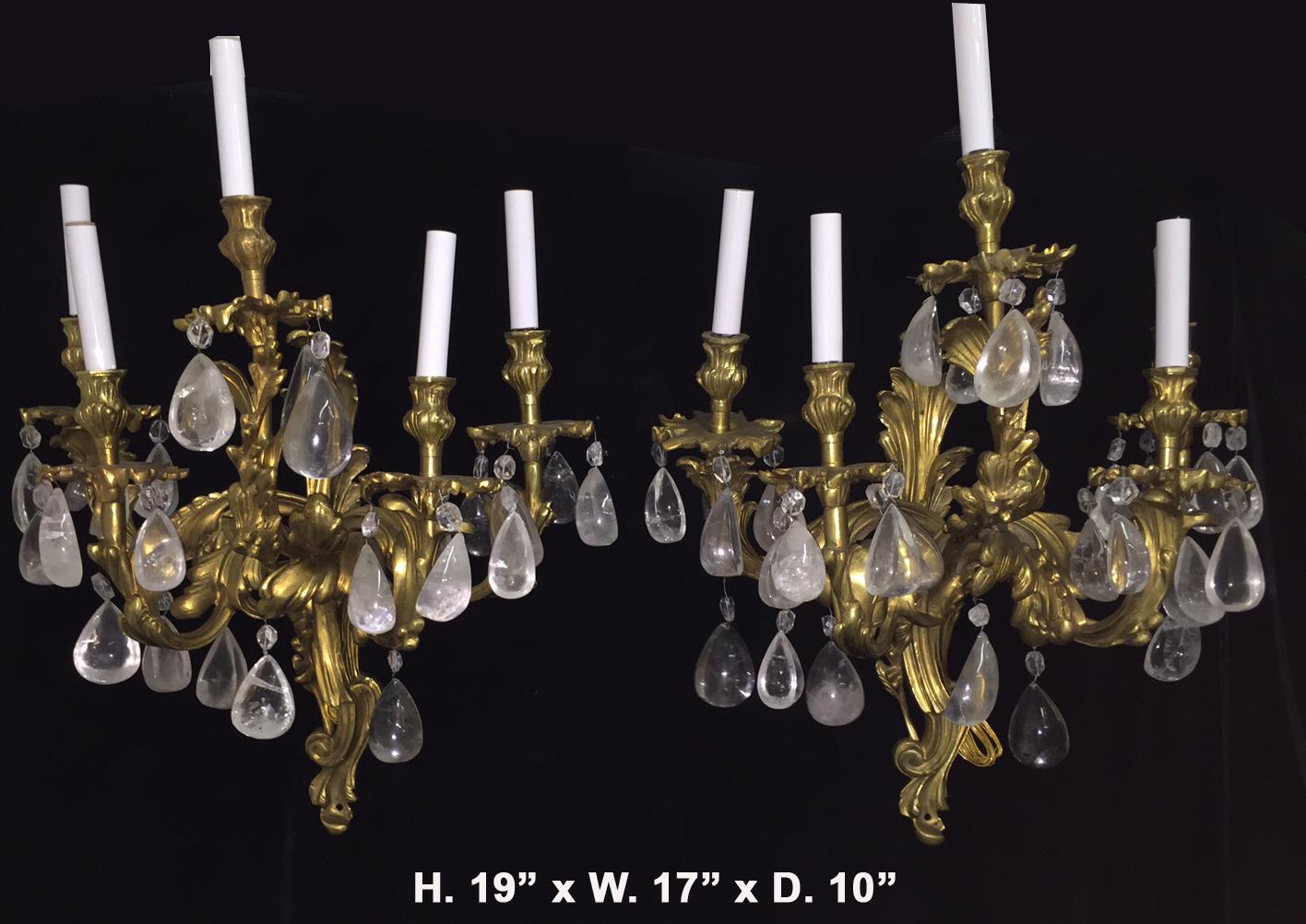 Lovely pair of French Louis XV style hand-carved and hand-polished rock crystal five light gilt bronze sconces,
late 20th century.
Each sconce is centered by a gilt bronze scrolling acanthus backplate, issuing foliate-inspired arms with conforming