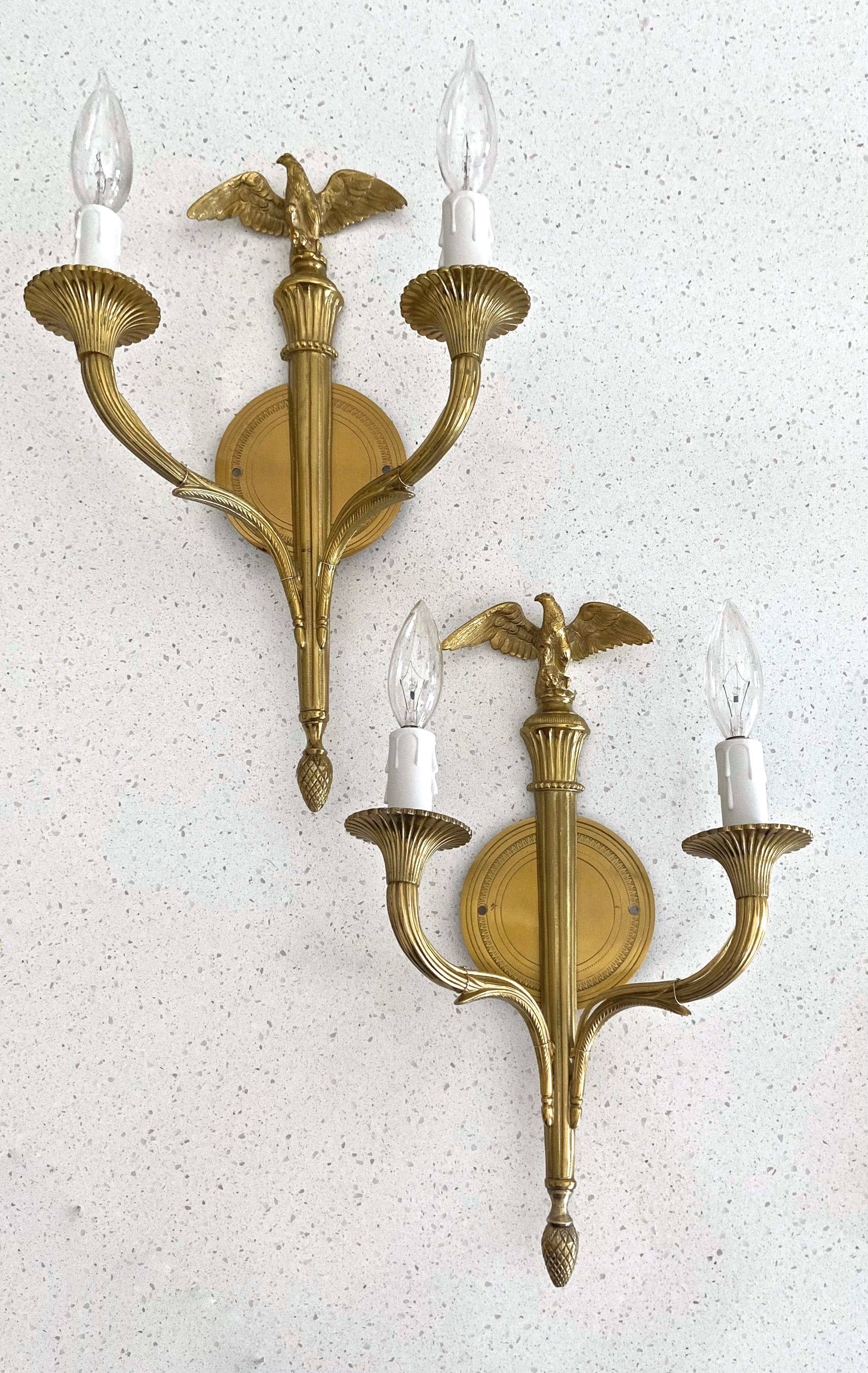 Pair of French Empire style doré gilt bronze wall sconces with eagle motif. The sconces are expertly crafted with fine detailing throughout. Each uses 2 candelabra size bulbs, newly wired (backplate 4.5